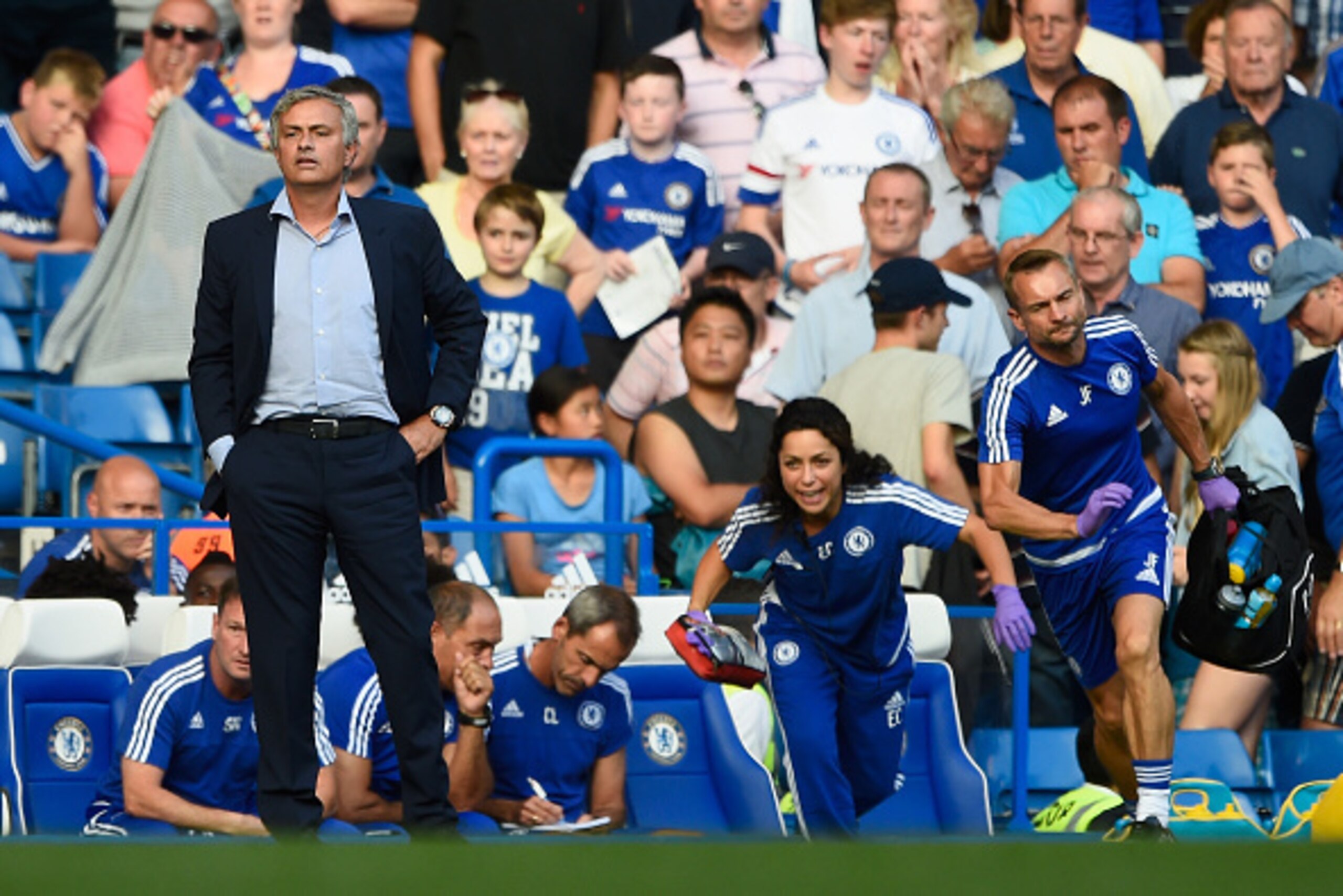 LONDON, ENGLAND - AUGUST 08:  Chelsea manager Jose Mourinho looks on as team doctor Eva Carneiro rushes to treat Eden Hazard during the Barclays Premier League match between Chelsea and Swansea City at Stamford Bridge on August 8, 2015 in London, England.