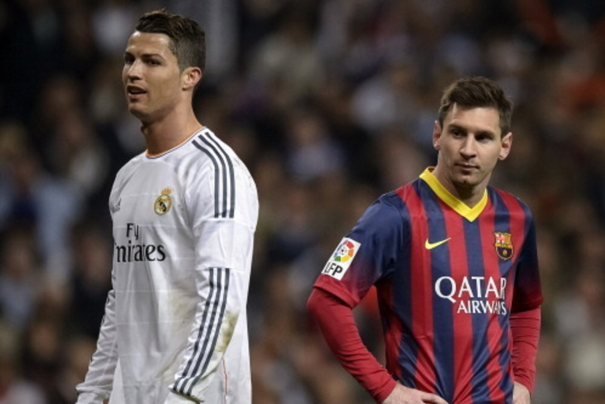 Barcelona's Argentinian forward Lionel Messi (R) stands past Real Madrid's Portuguese forward Cristiano Ronaldo during the 'El clasico' Spanish League football match Real Madrid vs Barcelona at the Santiago Bernabeu stadium in Madrid on March 23, 2014. Ba