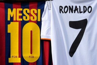 MADRID, SPAIN - MARCH 23:  Shirts bearing the names of Lionel Messi of FC Barcelona and Cristiano Ronaldo of Real Madrid CF are seen on display at a merchandise stall prior to the La Liga match between Real Madrid CF and FC Barcelona at estadio Santiago B