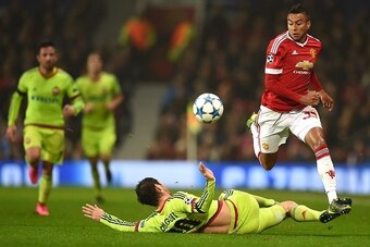 Manchester United's English midfielder Jesse Lingard (R) jumps a tackle by CSKA Moscow's midfielder Alan Dzagoev during a UEFA Chamions league group stage football match between CSKA Moscow and Manchester United at Old Trafford in Manchester, north west E