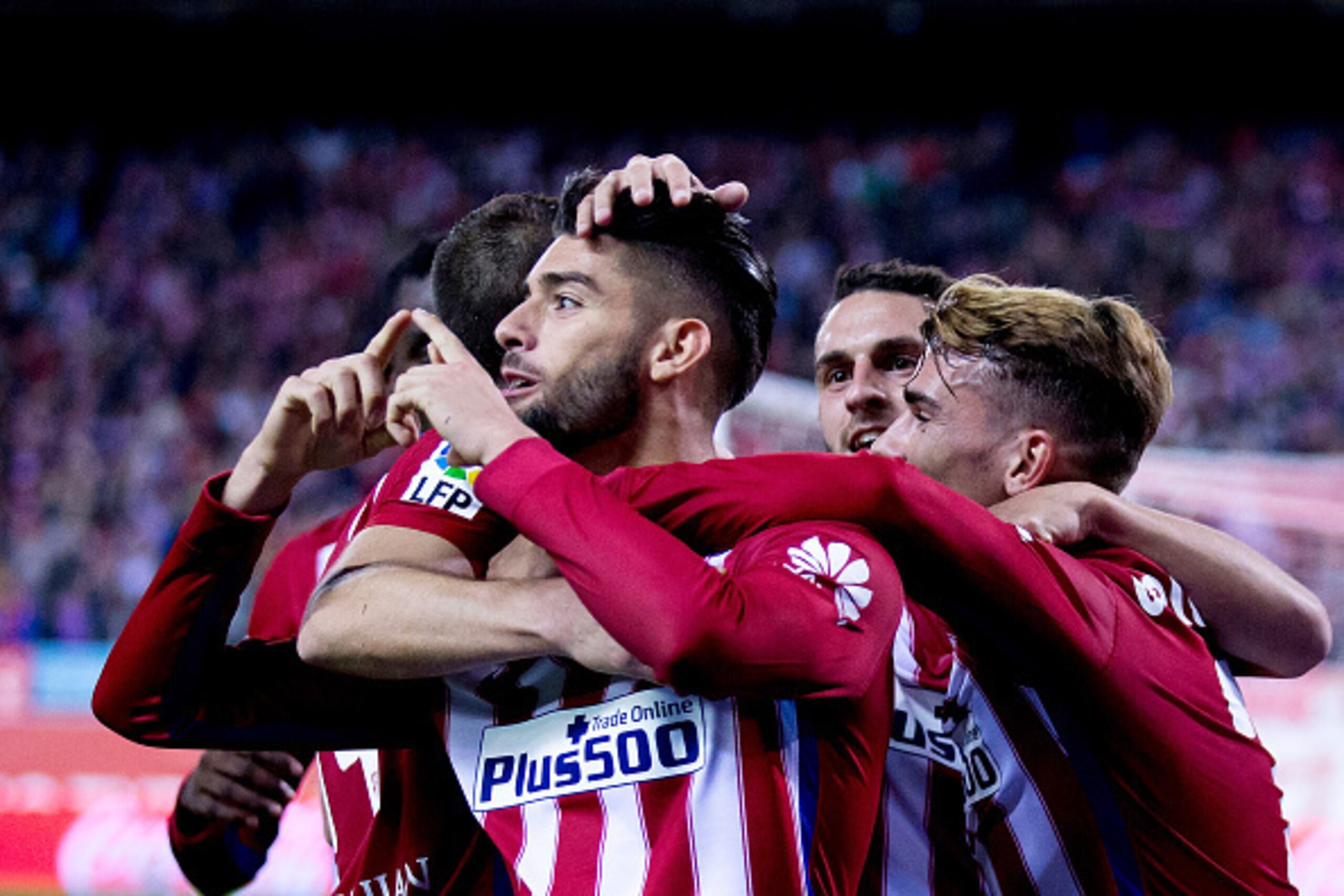 MADRID, SPAIN - OCTOBER 25:  Yannick Carrasco (L) of Atletico de Madrid celebrates scoring their second goal with teammates Antoine Griezmann (R) and Koke (2ndR) during the La Liga amtch between Club Atletico de Madrid and Valencia CF at Vicente Calderon 