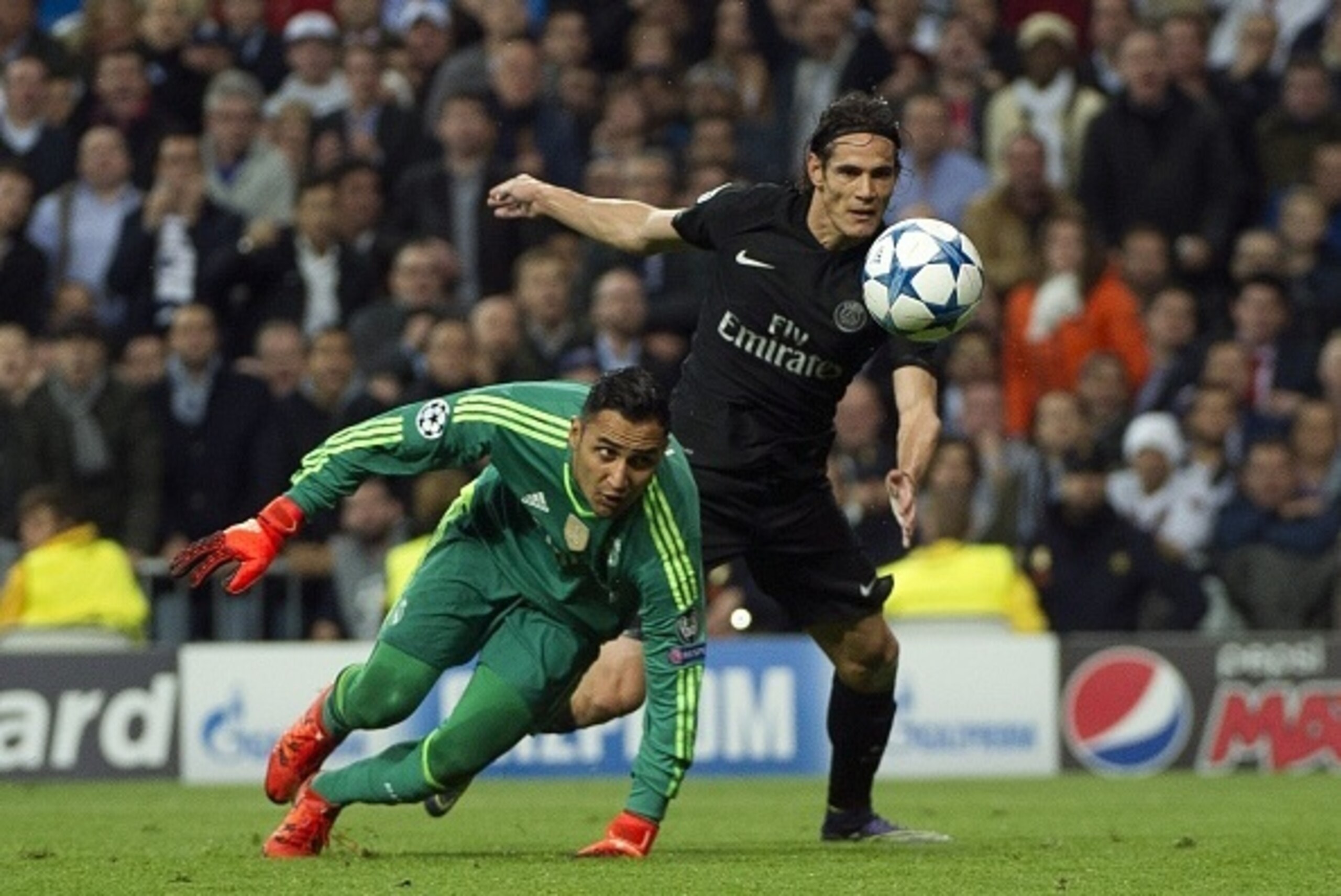 Real Madrid's Costa Rican goalkeeper Keylor Navas (L) vies with Paris Saint-Germain`s Uruguayan forward Edison Cavani during the UEFA Champions League group stage football match Real Madrid CF vs Paris Saint-Germain (PSG) at the Santiago Bernabeu stadium