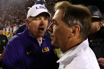BATON ROUGE, LA - NOVEMBER 08:  Head coach Les Miles of the LSU Tigers congratulates head coach Nick Saban of the Alabama Crimson Tide after the Tide defeated the Tigers 20-13 in overtime at Tiger Stadium on November 8, 2014 in Baton Rouge, Louisiana.  (P