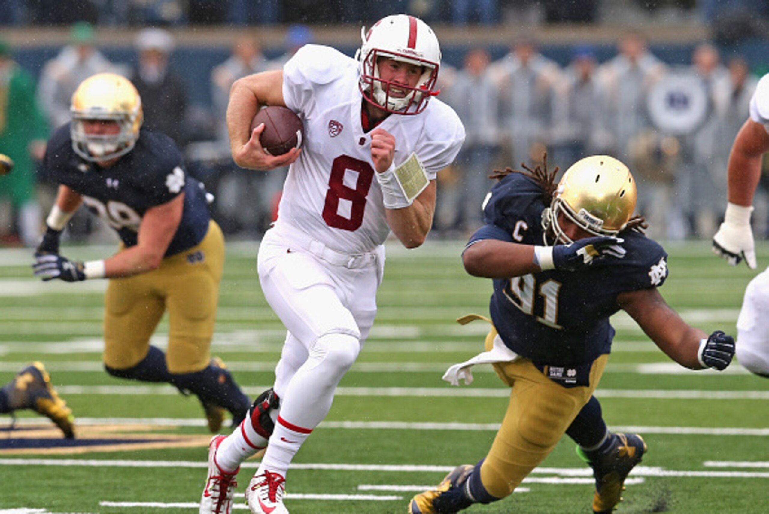 SOUTH BEND, IN - OCTOBER 04:  Kevin Hogan #8 of the Standford Cardinal runs past Sheldon Day #91 of the Notre Dame Fighting Irish at Notre Dame Stadium on October 4, 2014 in South Bend, Indiana. Notre Dame defeated Stanford 17-14.  (Photo by Jonathan Dani