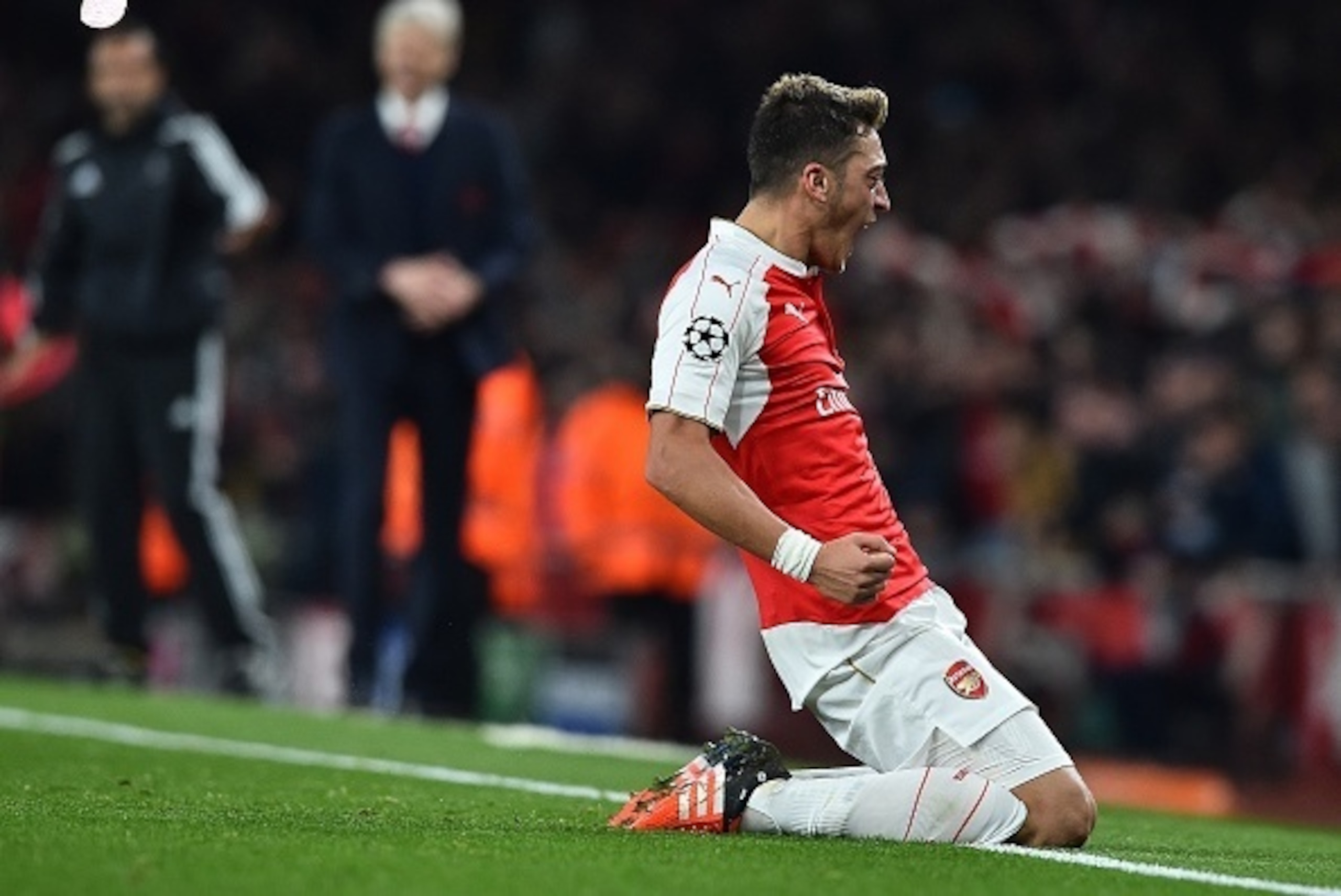 Arsenal's German midfielder Mesut Ozil (R) celebrates scoring his team's second goal during the UEFA Champions League football match between Arsenal and Bayern Munich at the Emirates Stadium in London, on October 20, 2015.  Arsenal won the match 2-0.  AFP