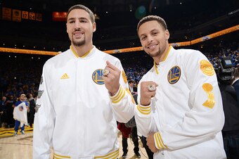 OAKLAND, CA - OCTOBER 27:  Klay Thompson #11 of the Golden State Warriors and Stephen Curry #30 of the Golden State Warriors display their championship rings before the game against the New Orleans Pelicans on October 27, 2015 at ORACLE Arena in Oakland, 