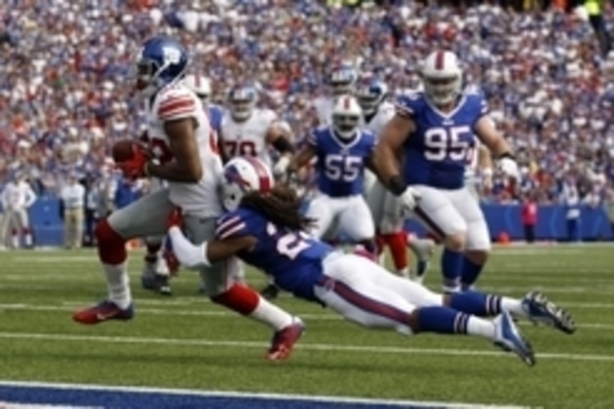 Oct 4, 2015; Orchard Park, NY, USA; New York Giants wide receiver Rueben Randle (82) runs the ball in for a touchdown during the first half while being defended by Buffalo Bills cornerback Stephon Gilmore (24) at Ralph Wilson Stadium. Mandatory Credit: Ti