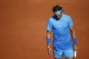 Spain's Rafael Nadal leaves the court following his defeat against Serbia's Novak Djokovic at the end of their men's quarter final match of the Roland Garros 2015 French Tennis Open in Paris on June 3, 2015. AFP PHOTO / KENZO TRIBOUILLARD        (Photo cr