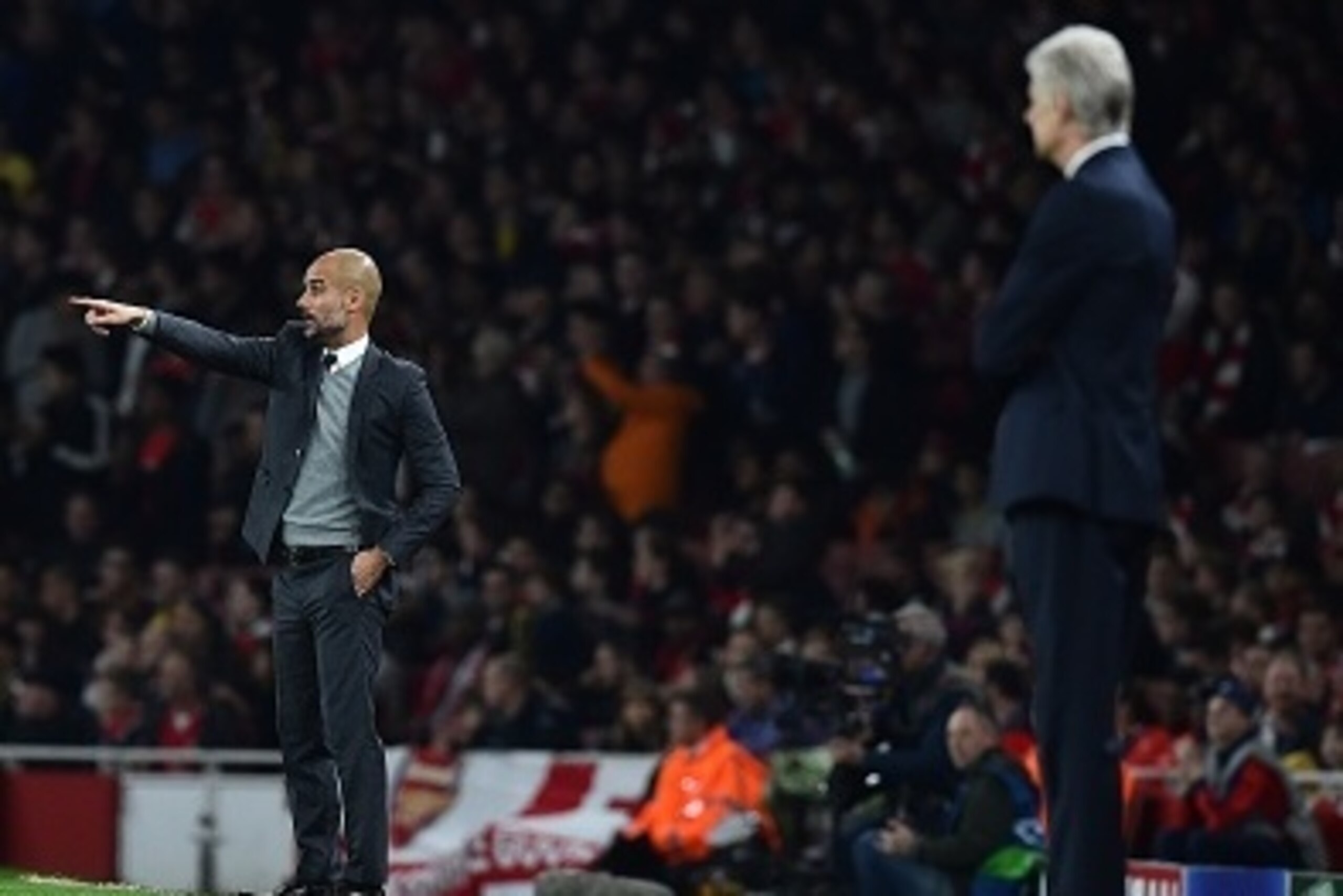 Arsenal's French manager Arsene Wenger (R) watches as Bayern Munich's Spanish head coach Pep Guardiola (C) gestures to his players during the UEFA Champions League football match between Arsenal and Bayern Munich at the Emirates Stadium in London, on Octo