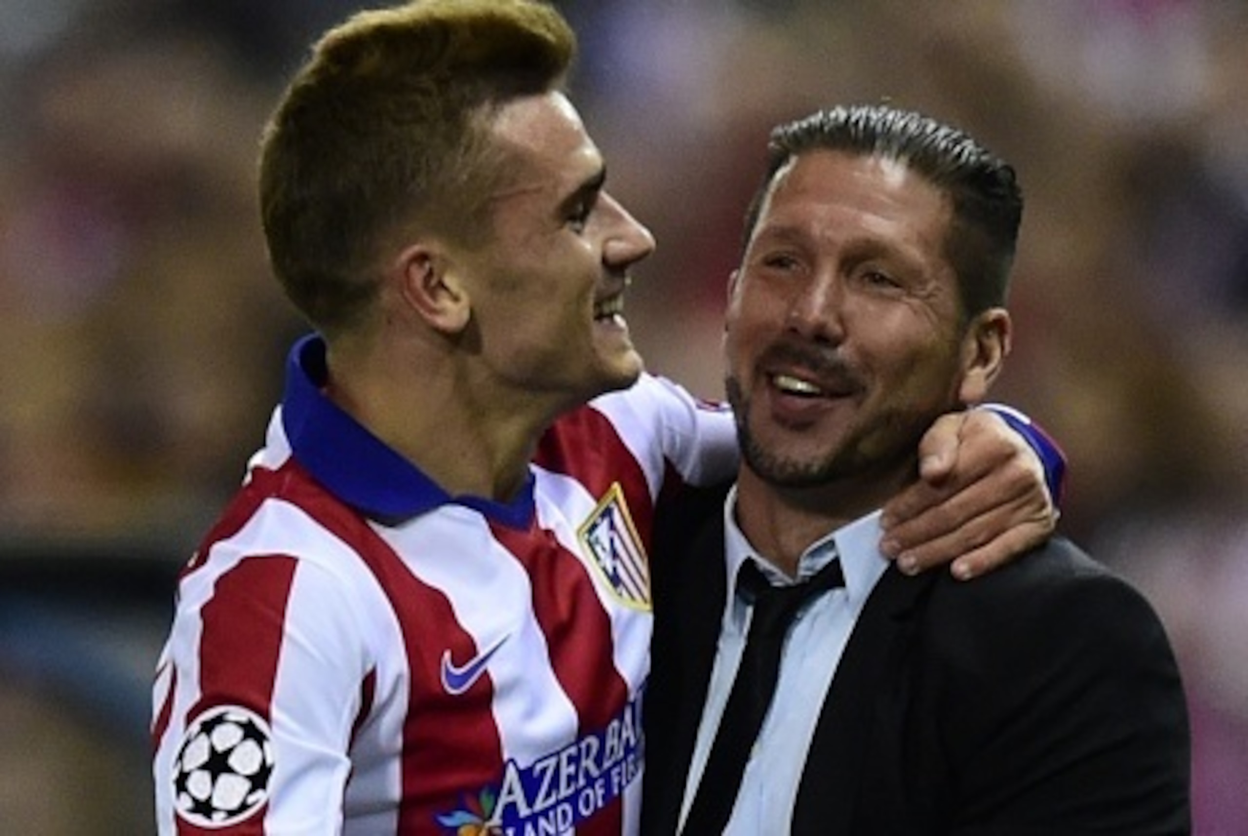 Atletico Madrid's French forward Antoine Griezmann (L) celebrates with Atletico Madrid's Argentinian coach Diego Simeone after scoring their third team goal during the UEFA Champions League football match Club Atletico de Madrid vs Malmo FF at the Vicente