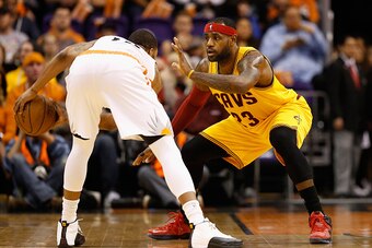 PHOENIX, AZ - JANUARY 13:   LeBron James #23 of the Cleveland Cavaliers defends against Marcus Morris #15 of the Phoenix Suns during the NBA game at US Airways Center on January 13, 2015 in Phoenix, Arizona.   The Suns defeated the Cavaliers 107-100.  NOT