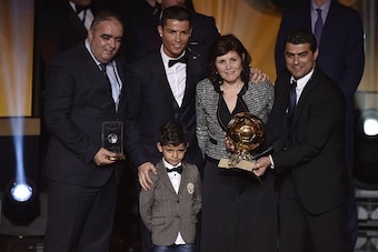 Real Madrid and Portugal forward Cristiano Ronaldo (C) poses with his son Cristiano Jr (2nd L), mother Dolores (2nd R), brother Hugo (R) and an unidentified family member   after receiving the 2014 FIFA Ballon d'Or award for player of the year during the 