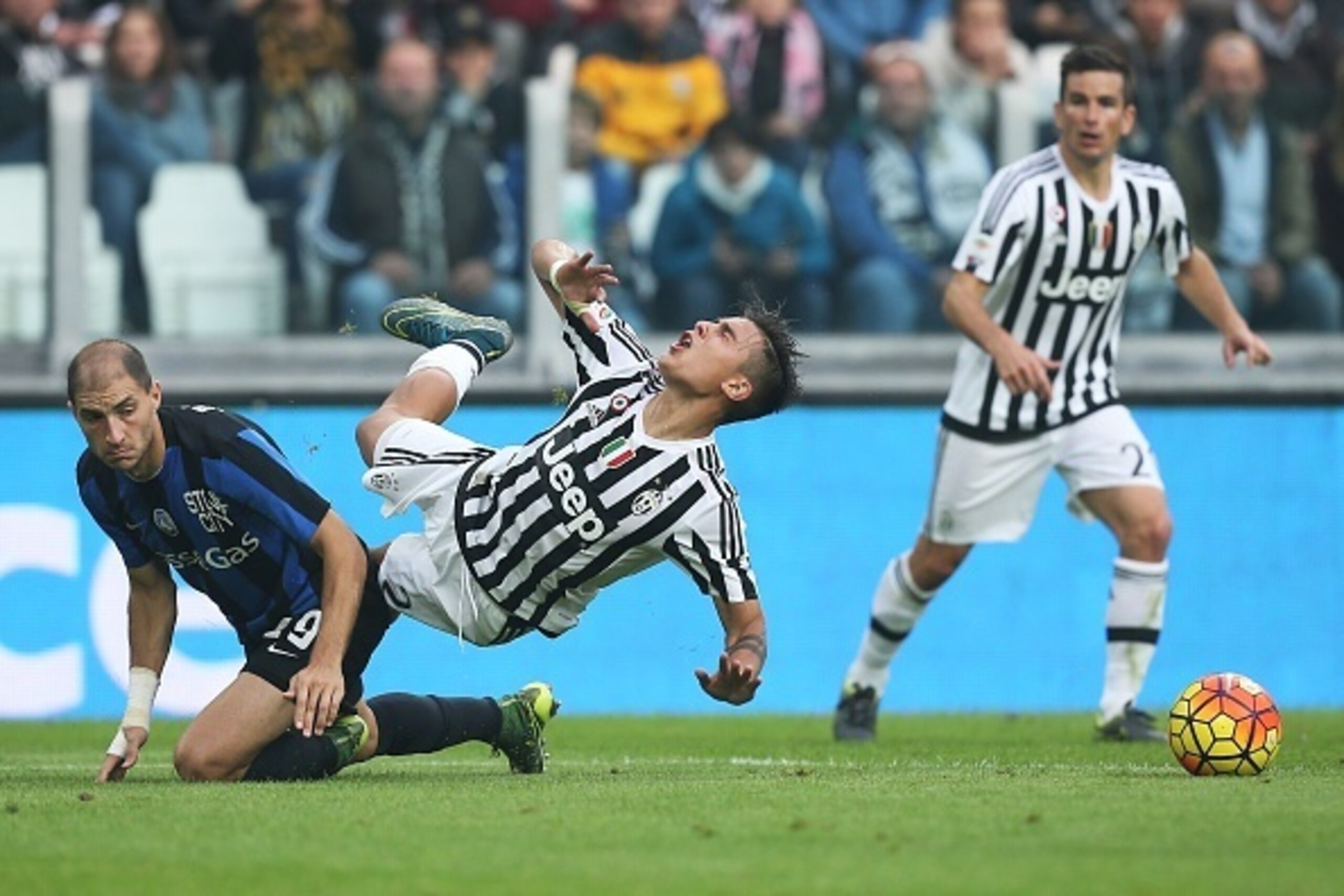 Juventus' forward Paulo Dybala from Argentina (C ) is tackled by Atalanta's defender Gabriel Paletta during the Italian Serie A football match Juventus Vs Atalanta on October 25, 2015 at the 'Juventus Stadium' in Turin.  AFP PHOTO / MARCO BERTORELLO      