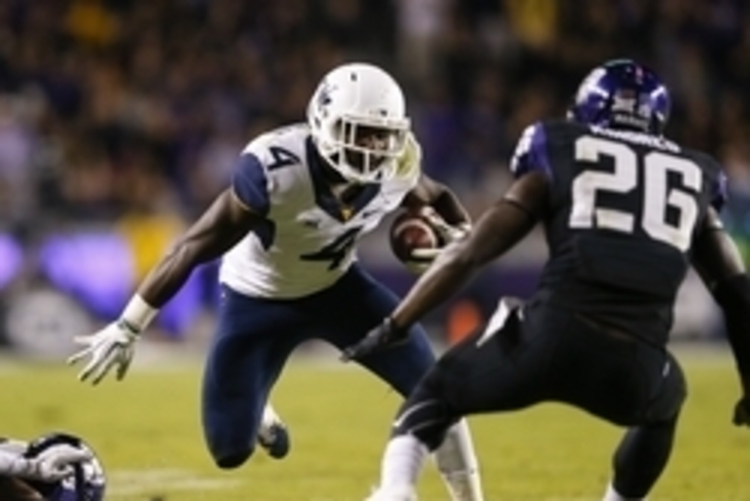 Oct 29, 2015; Fort Worth, TX, USA; West Virginia Mountaineers running back Wendell Smallwood (4) runs as TCU Horned Frogs safety Derrick Kindred (26) defends during the game at Amon G. Carter Stadium. Mandatory Credit: Kevin Jairaj-USA TODAY Sports