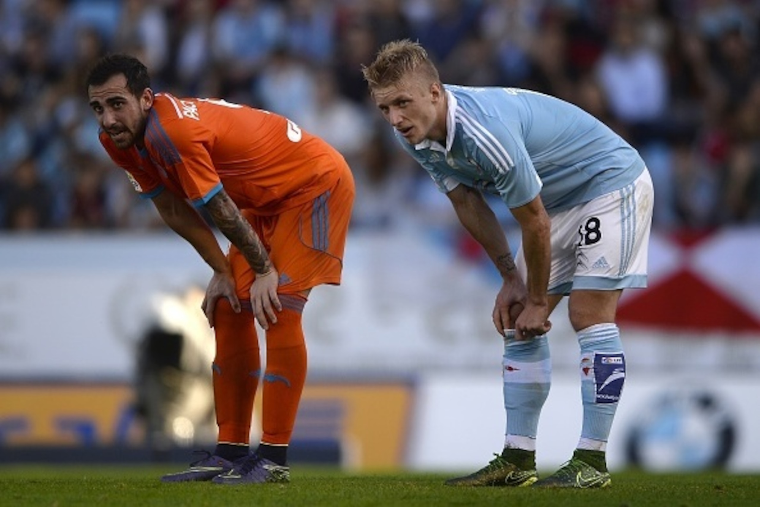 Valencia's forward Paco Alcacer (L) and Celta Vigo's Danish defender Daniel Wass react during the Spanish league football match RC Celta de Vigo vs Valencia CF at the Balaidos stadium in Vigo on November 7, 2015.  Valencia won the match 5-1.  AFP PHOTO/ M
