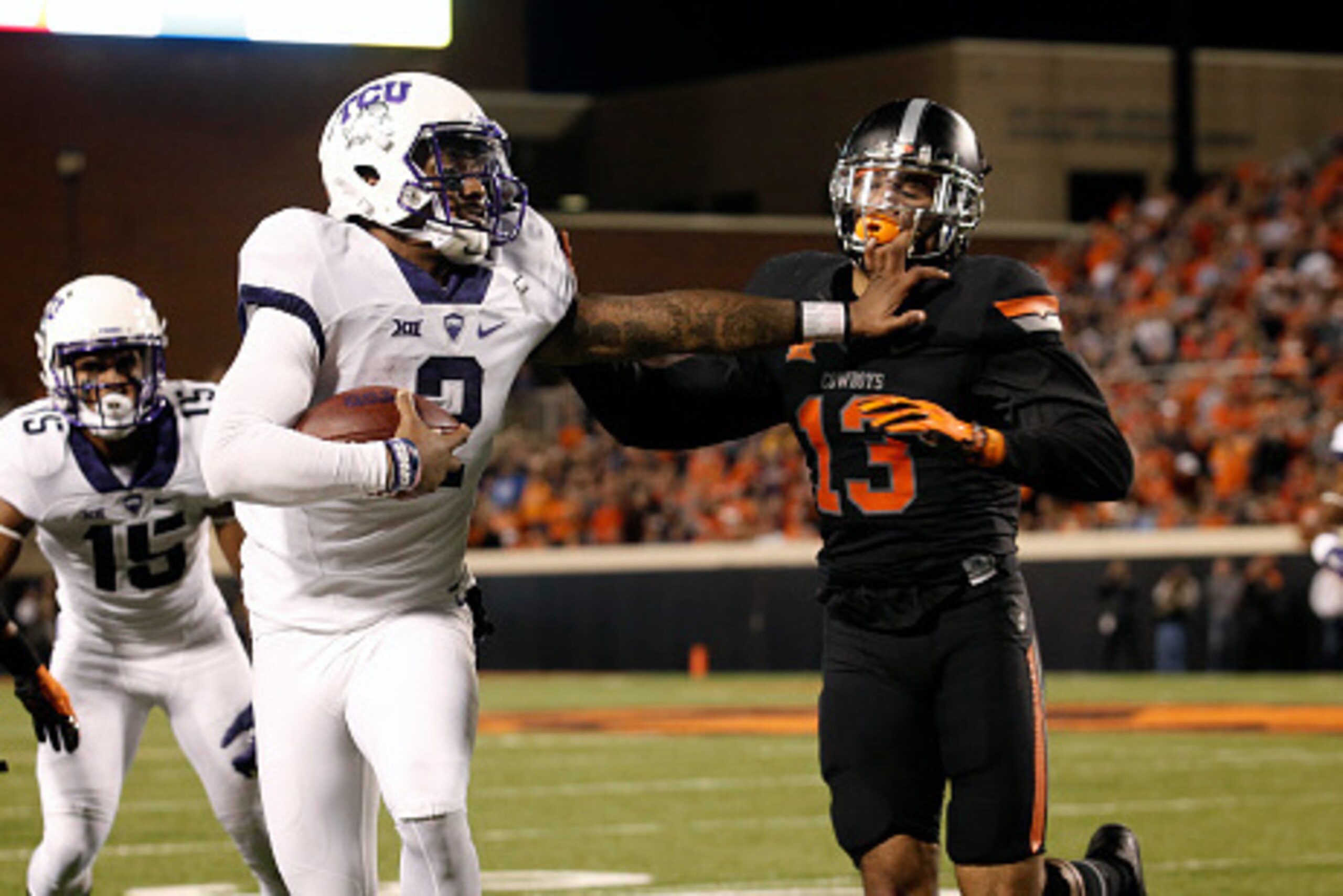 STILLWATER, OK - NOVEMBER 7 :  Quarterback Trevone Boykin #2 of the TCU Horned Frogs pushes safety Jordan Sterns #13 of the Oklahoma State Cowboys November 7, 2015 at Boone Pickens Stadium in Stillwater, Oklahoma. The Cowboys defeated the Horned Frogs 49-