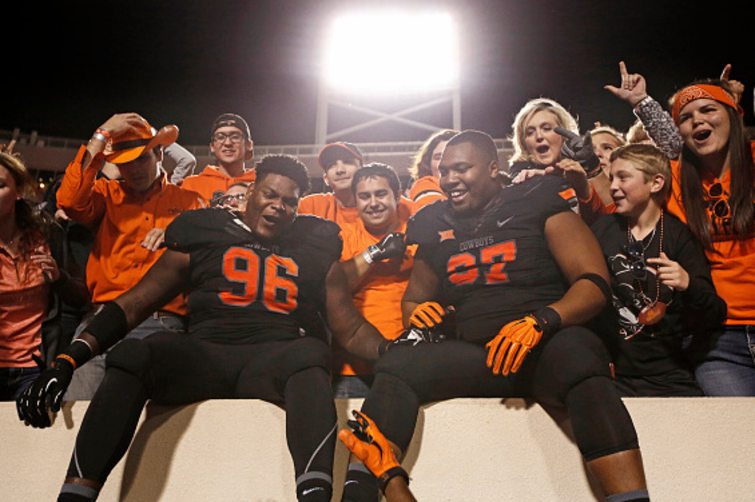 STILLWATER, OK - NOVEMBER 7 : Defensive tackle Vincent Taylor #96 and defensive tackle Eric Davis #97 of the Oklahoma State Cowboys celebrate with the fans in the stands after the game against the TCU Horned Frogs November 7, 2015 at Boone Pickens Stadium