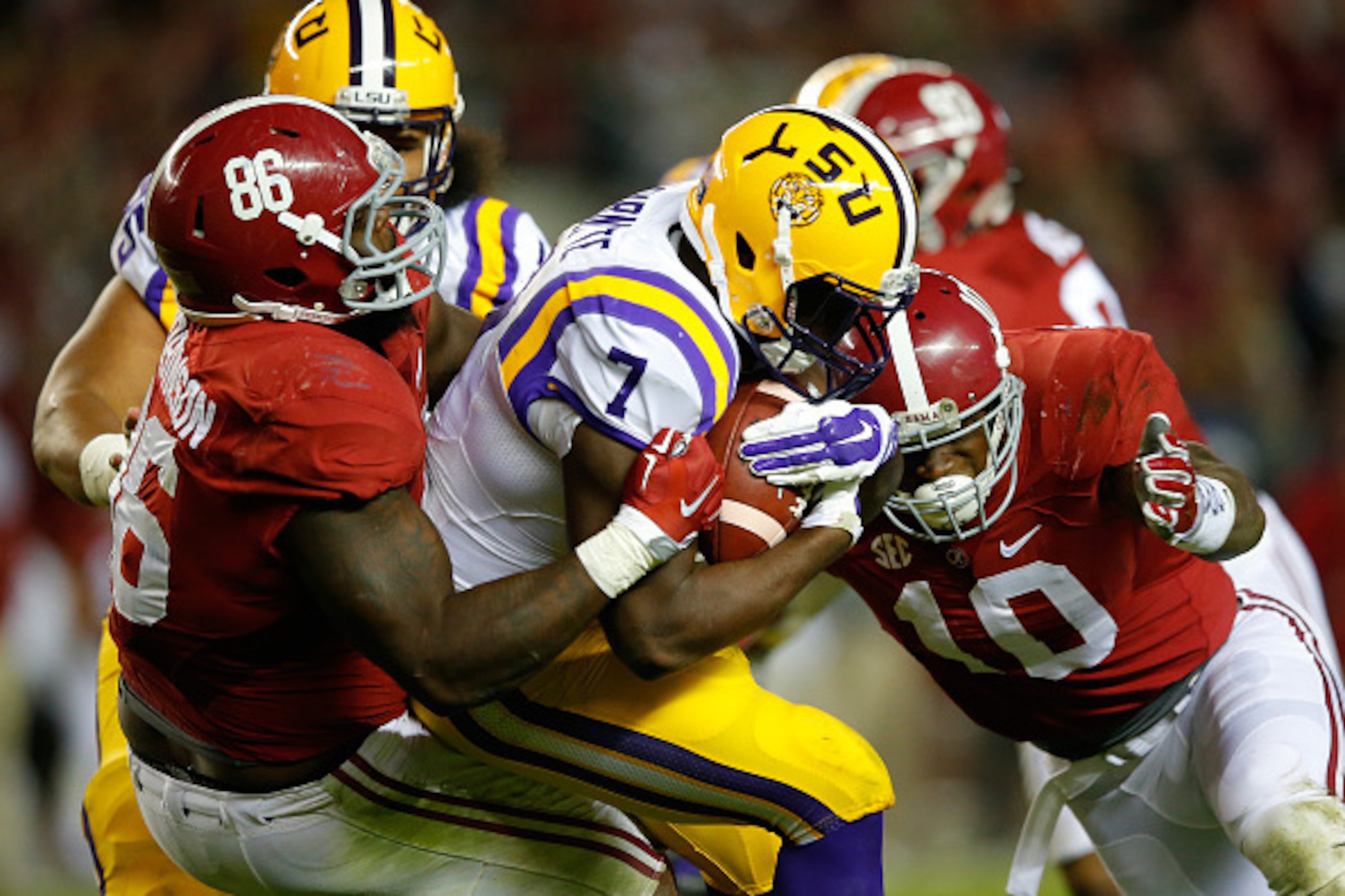 TUSCALOOSA, AL - NOVEMBER 07:  Leonard Fournette #7 of the LSU Tigers is tackled by Reuben Foster #10 and Truett Harris #86 of the Alabama Crimson Tide in the third quarter at Bryant-Denny Stadium on November 7, 2015 in Tuscaloosa, Alabama.  (Photo by Kev