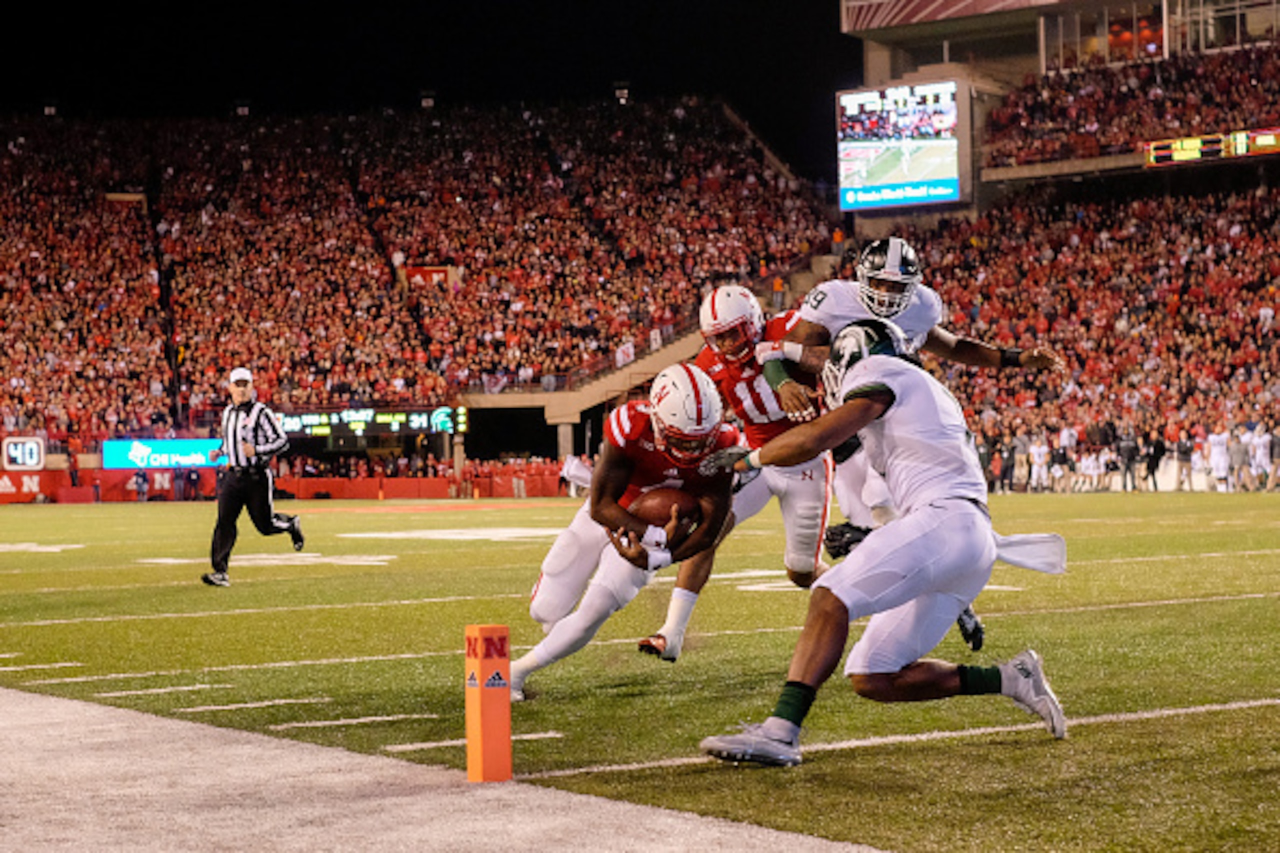 LINCOLN, NE - NOVEMBER 7: Quarterback Tommy Armstrong Jr. #4 of the Nebraska Cornhuskers scores after he runs over defensive back Demetrious Cox #7 of the Michigan State Spartans during their game at Memorial Stadium on November 7, 2015 in Lincoln, Nebras