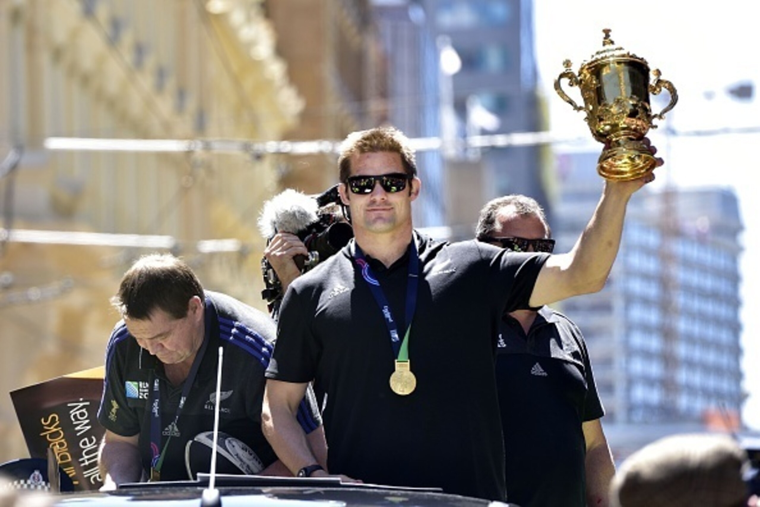 New Zealand's All Blacks rugby team captain Richie McCaw (C) holds the Webb Ellis Cup during a parade by the team through the central business district of Wellington on November 6, 2015, following their Rugby World Cup win against Australia in England on 