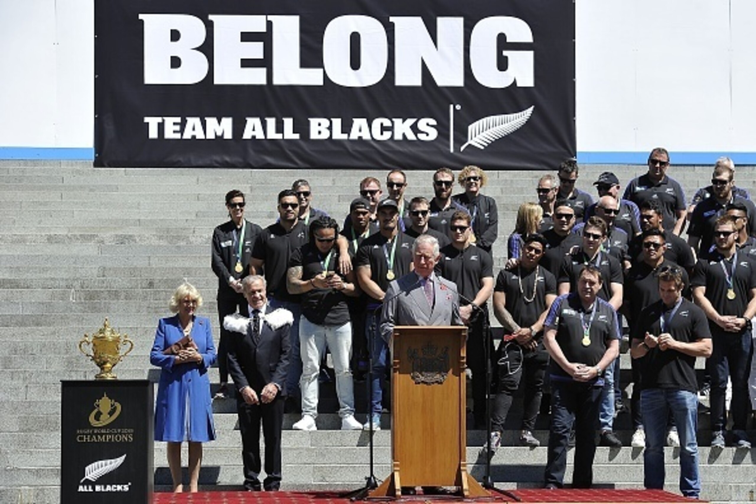 Britain's Prince Charles (C) speaks as his wife Camilla (L), the Duchess of Cornwall and speaker of the house David Carter (2nd L) and members of New Zealand's All Blacks team listen during a parade through the central business district of Wellington on N