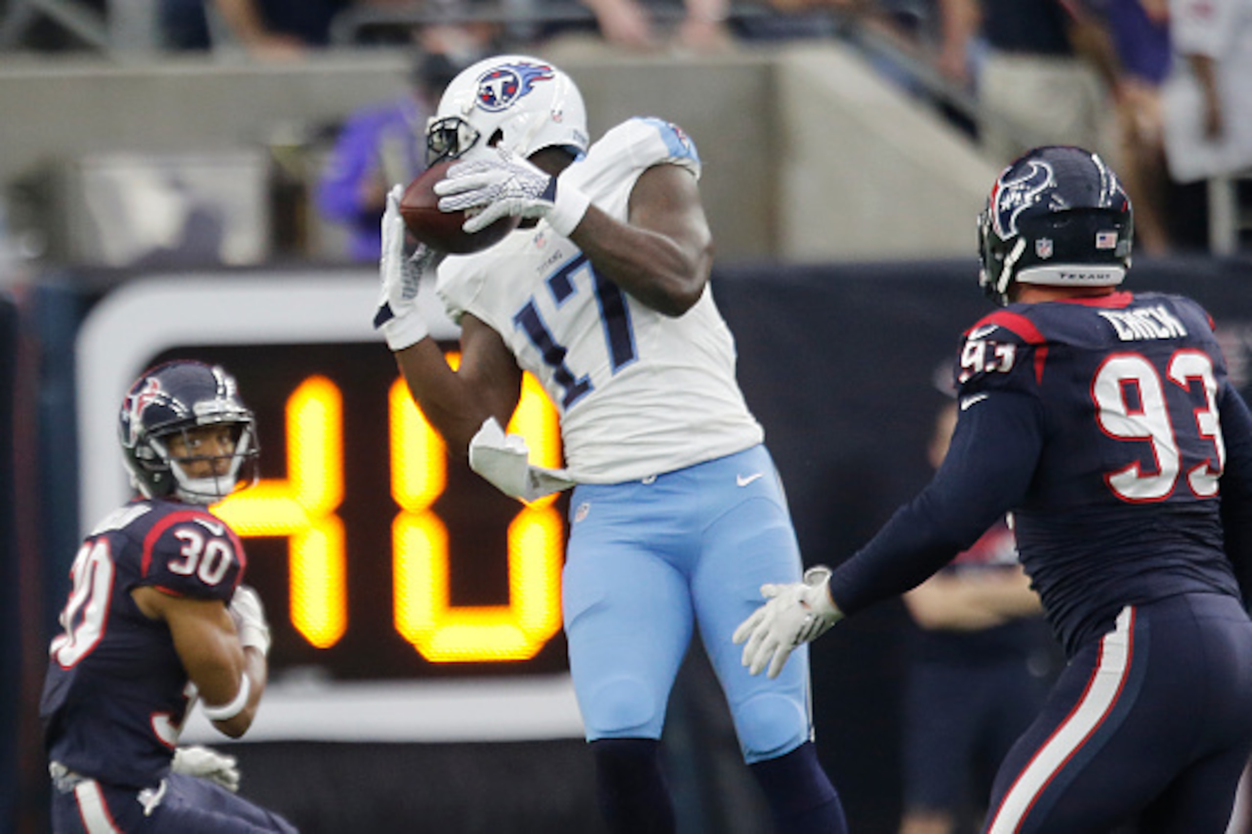 HOUSTON, TX - NOVEMBER 01: Dorial Green-Beckham #17 of the Tennessee Titans makes a catch on a deflection while Kevin Johnson #30  and Jared Crick #93 of the Houston Texans defend in the first quarter on November 1, 2015 at NRG Stadium in Houston, Texas. 
