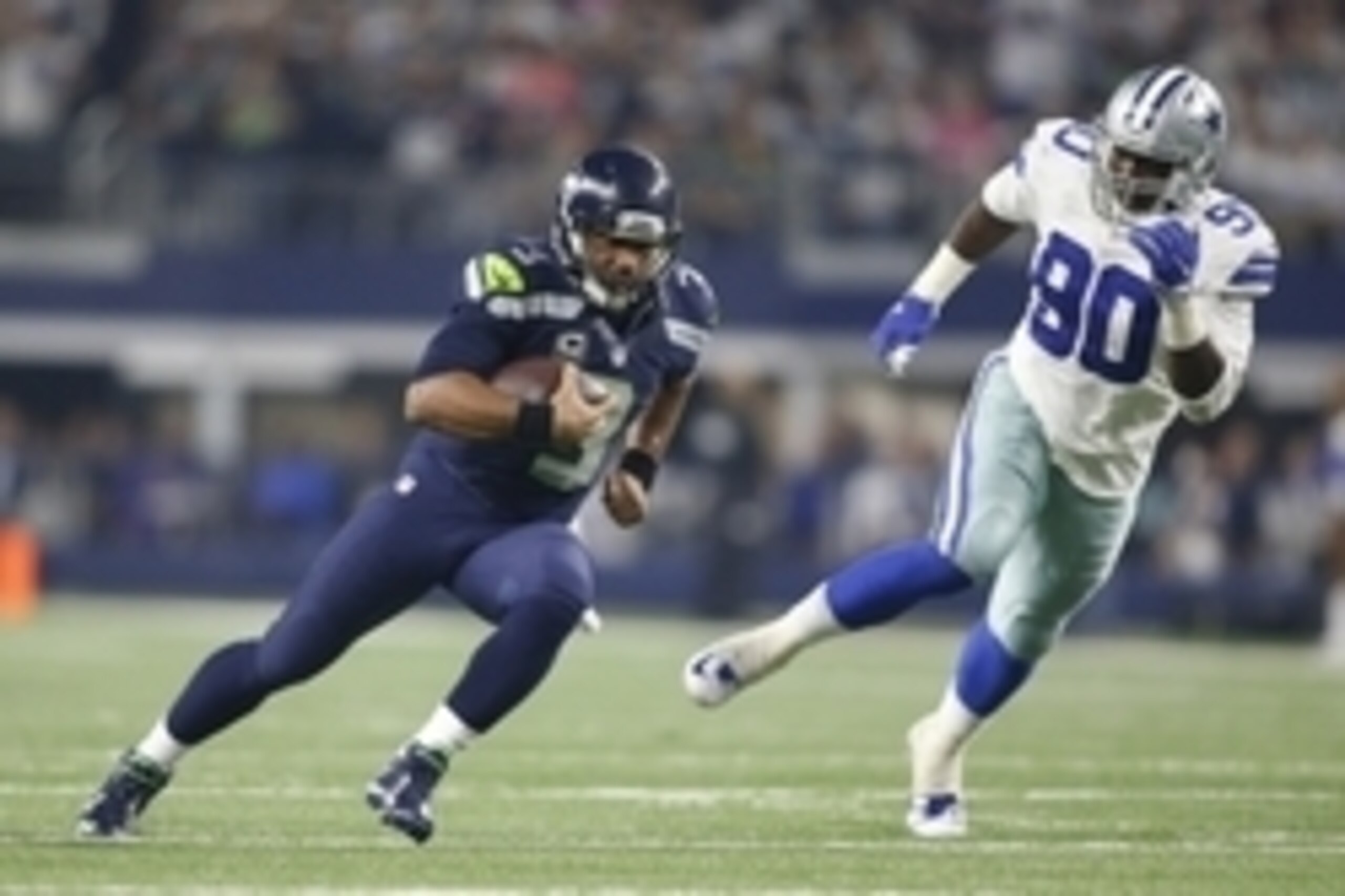 Nov 1, 2015; Arlington, TX, USA;  Seattle Seahawks quarterback Russell Wilson (3) scrambles for a first down against Dallas Cowboys defensive end Demarcus Lawrence (90) in the fourth quarter at AT&T Stadium. Seattle won 13-12. Mandatory Credit: Tim Heitma
