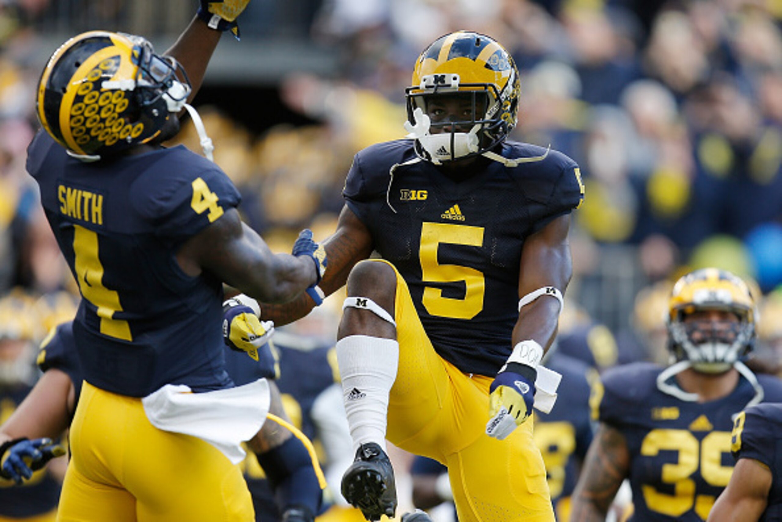 ANN ARBOR, MI - NOVEMBER 07:  Jabrill Peppers #5 and De'Veon Smith #4 of the Michigan Wolverines take the field prior to playing the Rutgers Scarlet Knights on November 7, 2015 at Michigan Stadium in Ann Arbor, Michigan. Michigan won the game 49-16.  (Pho