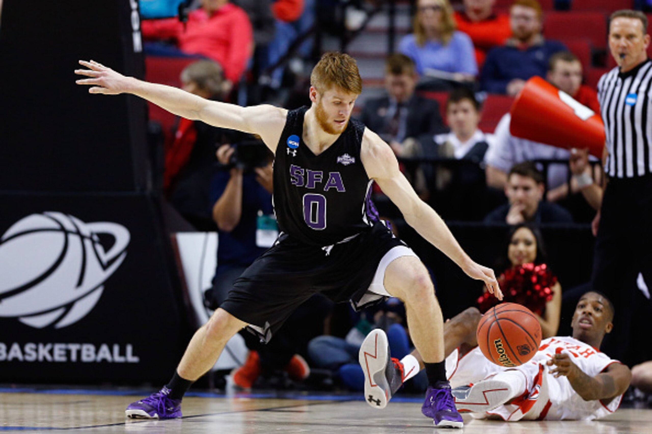 PORTLAND, OR - MARCH 19: Thomas Walkup #0 of the Stephen F. Austin Lumberjacks tries to control the ball as Delon Wright #55 of the Utah Utes falls to the court during the second round of the 2015 NCAA Men's Basketball Tournament at Moda Center on March 1