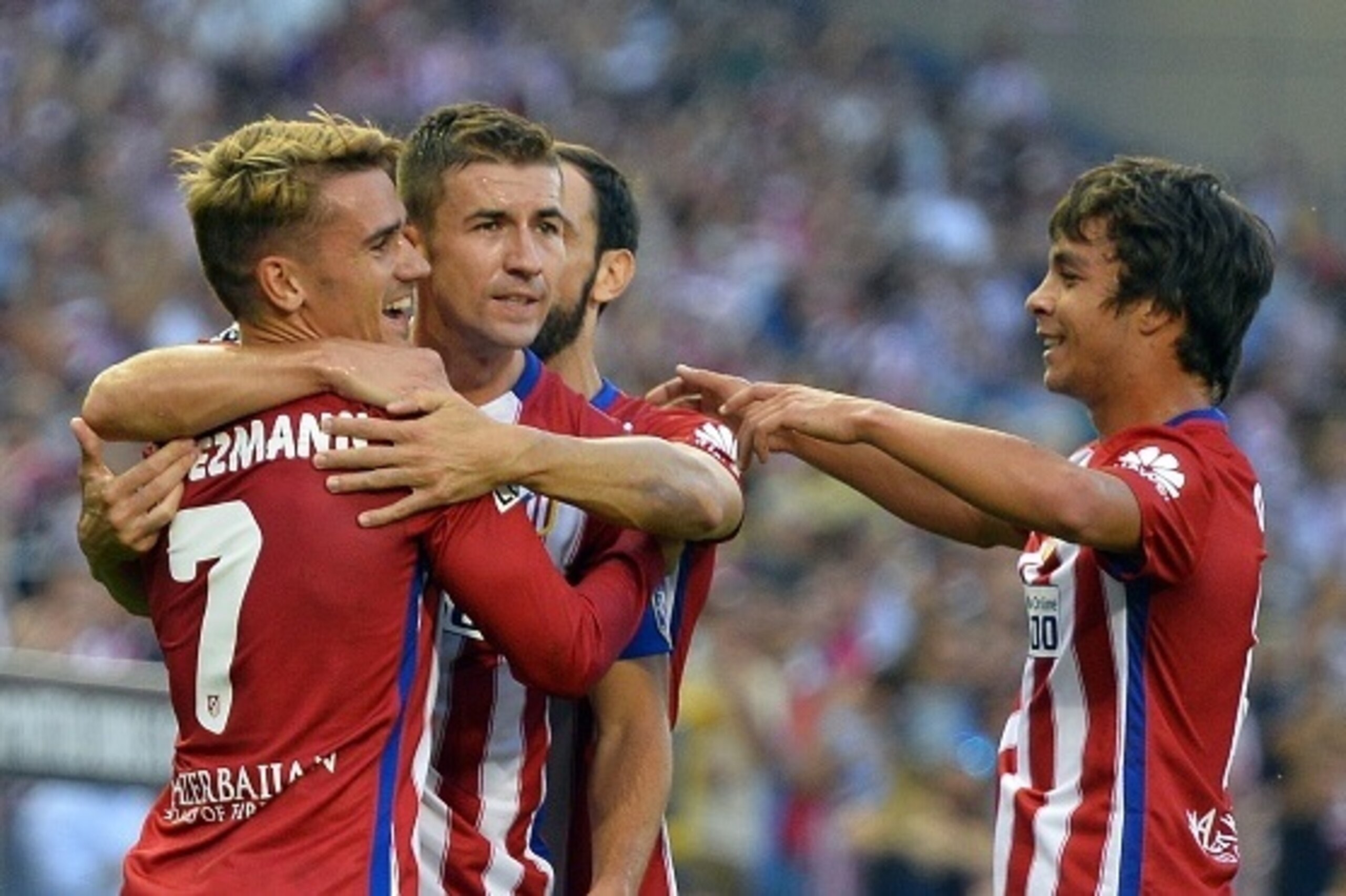 Atletico Madrid's French forward Antoine Griezmann (L) is congratuled by Atletico Madrid's midfielder Oliver Torres during the Spanish league football match Club Atletico de Madrid vs UD Las Palmas at the Vicente Calderon stadium in Madrid on August 22, 2