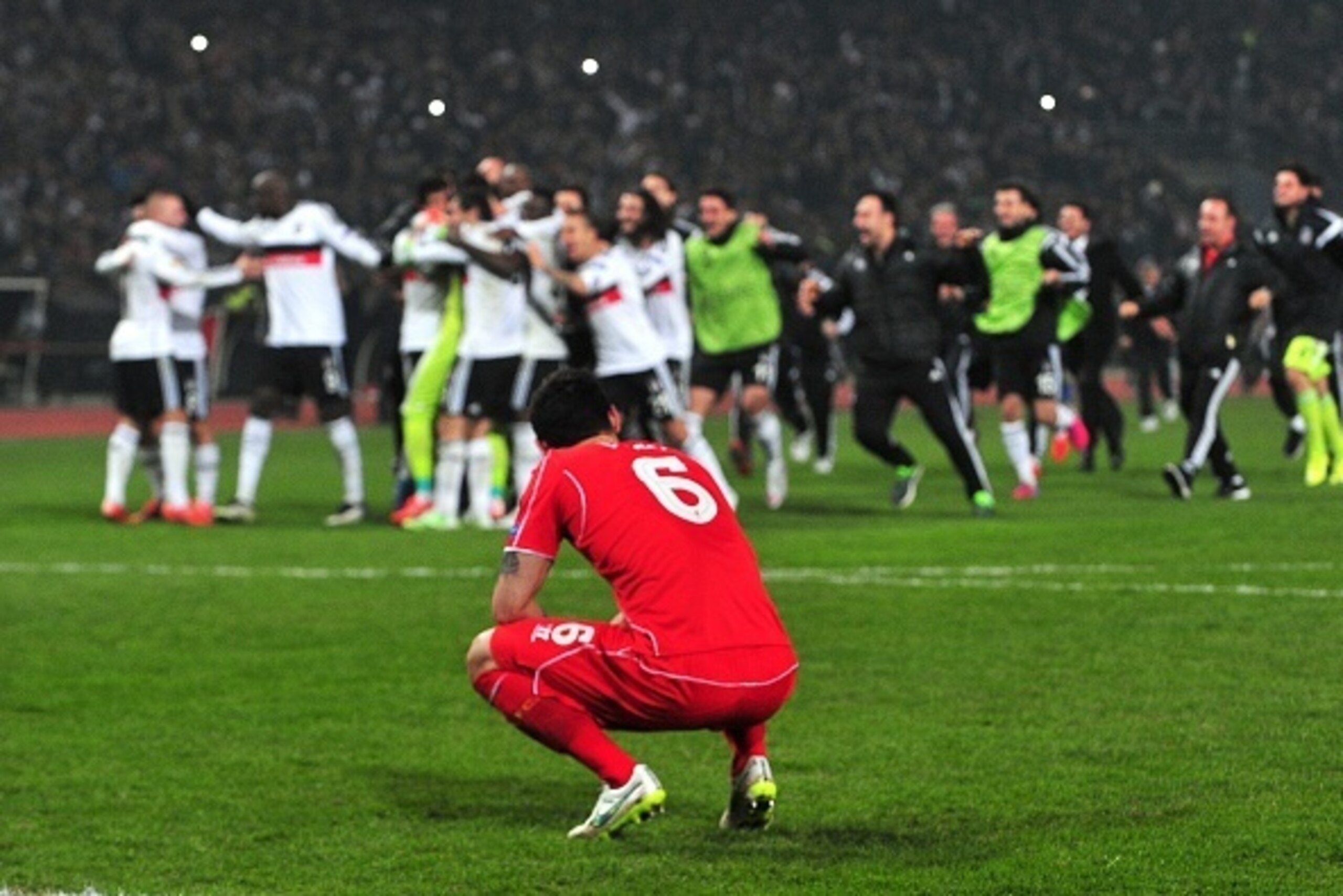 Liverpool's Dejn Lovren reacts after missing the last penalty while Besiktas' players celebrate during the UEFA Europa League round of 32 second-leg football match Besiktas vs Liverpool at Ataturk Olympic Stadium in Istanbul on February 26, 2015.  AFP PHO