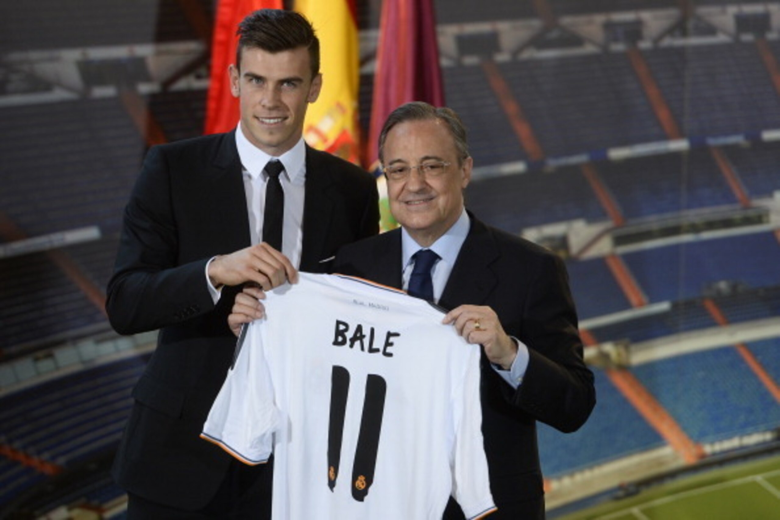 New Welsh striker Gareth Bale of Real Madrid (L) poses with his new jersey next to Real Madrid's President Florentino Perez during his presentation at the Santiago Bernabeu stadium in Madrid on September 2, 2013. Bale was unveiled as a Real Madrid player 