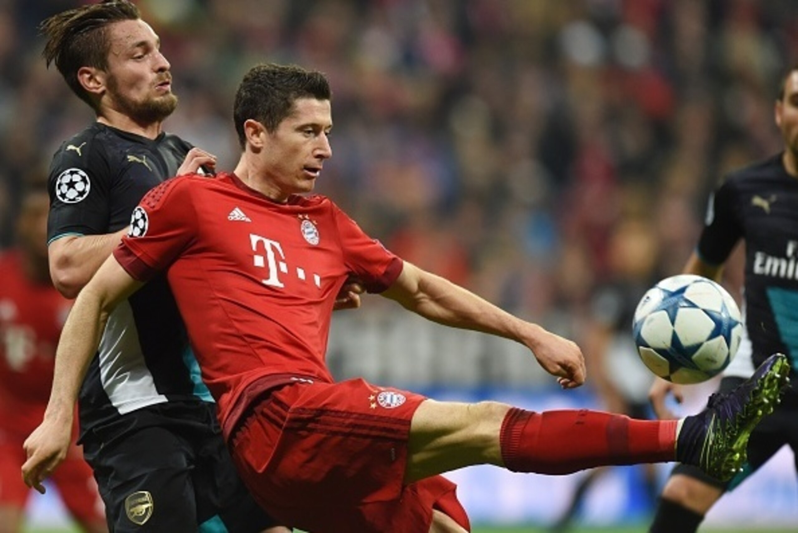 Arsenal's French defender Mathieu Debuchy (L) and Bayern Munich's Polish striker Robert Lewandowski vie for the ball during the UEFA Champions League Group F second-leg football match between FC Bayern Munich and Arsenal FC in Munich, southern Germany, on