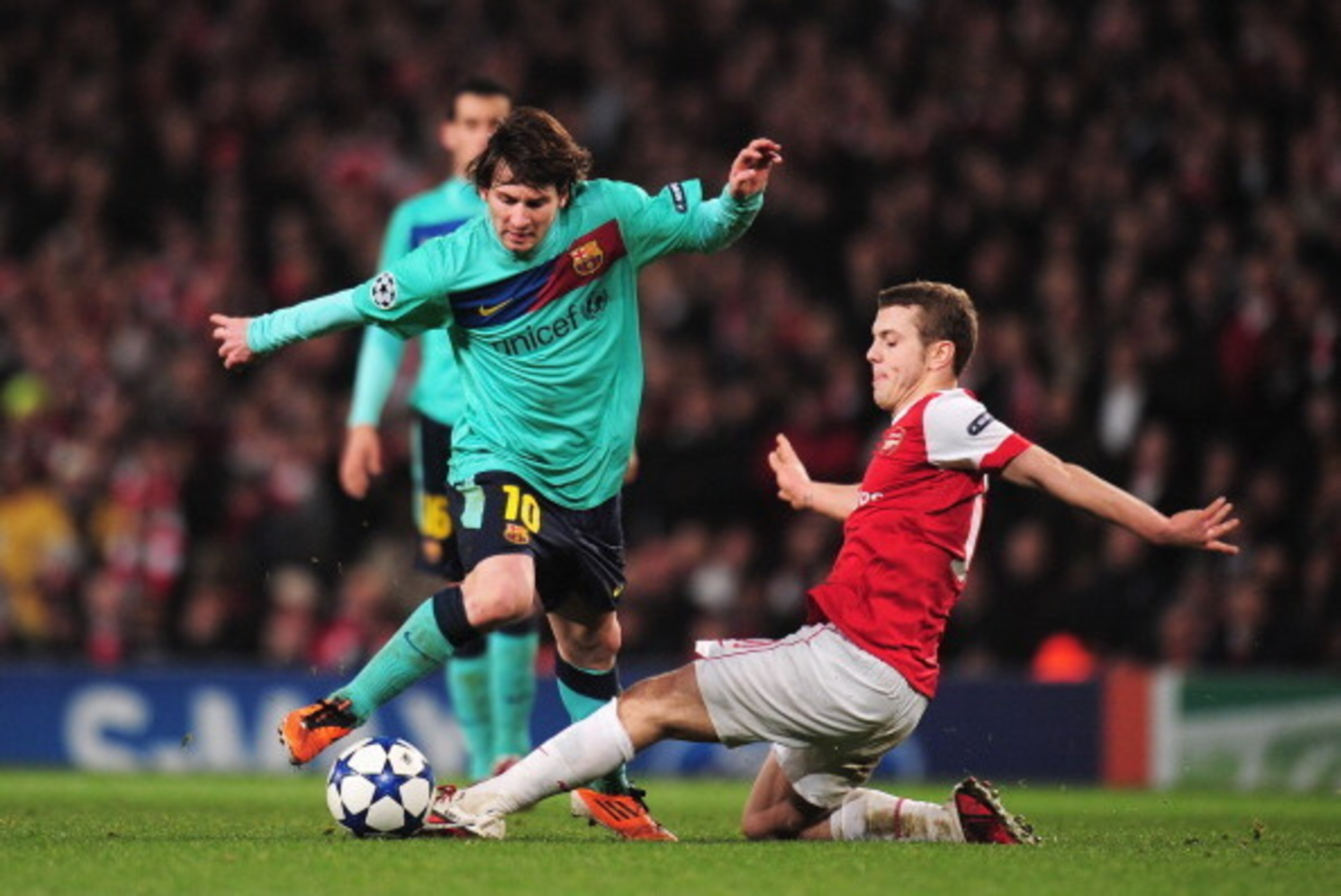 LONDON, ENGLAND - FEBRUARY 16: Lionel Messi of Barcelona is challenged by  Jack Wilshere of Arsenal   during the UEFA Champions League round of 16 first leg match between Arsenal and Barcelona at the Emirates Stadium on February 16, 2011 in London, Englan