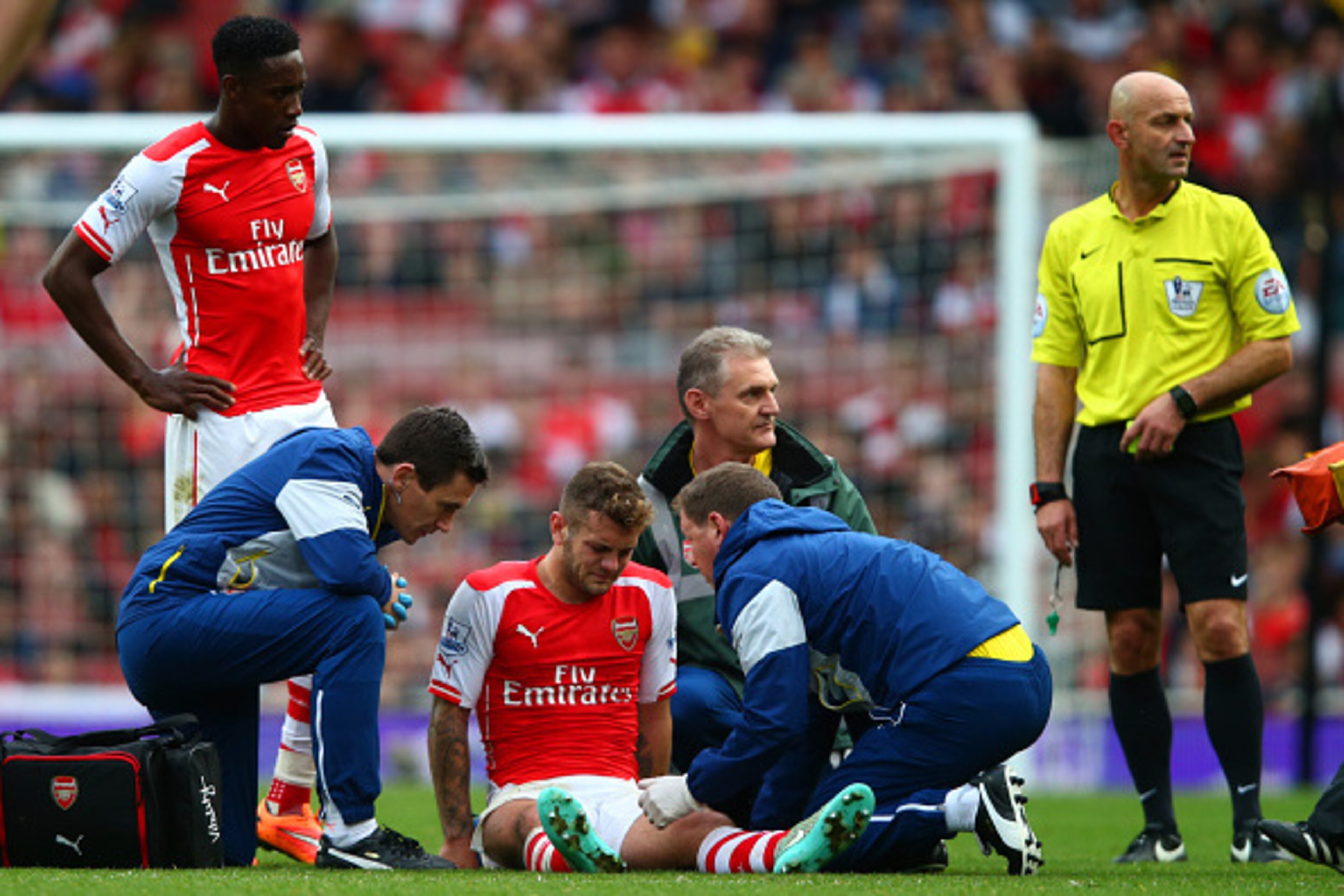 LONDON, ENGLAND - OCTOBER 18:  Jack Wilshere of Arsenal receives treatment before being substituted with an injury during the Barclays Premier League match between Arsenal and Hull City at Emirates Stadium on October 18, 2014 in London, England.  (Photo b