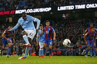 Manchester City's Ivorian midfielder and captain Yaya Toure scores their fourth goal from the penalty spot during the English League Cup fourth round football match between Manchester City and Crystal Palace at The Etihad Stadium in Manchester, north west
