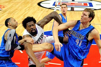 LOS ANGELES CA - OCTOBER 29: DeAndre Jordan #6 of the Los Angeles Clippers is fouled by Dirk Nowitzki #41 and Devin Harris of the Dallas Mavericks during the second quarter of the basketball game Staples Center October 29, 2015, in Los Angeles California.