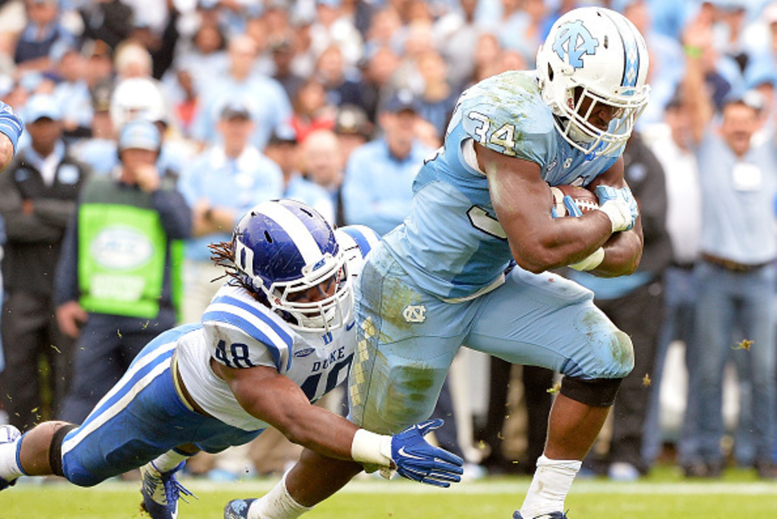 CHAPEL HILL, NC - NOVEMBER 07:  Deion Williams #48dives to tackle Elijah Hood #34 of the North Carolina Tar Heels during their game at Kenan Stadium on November 7, 2015 in Chapel Hill, North Carolina.  (Photo by Grant Halverson/Getty Images)