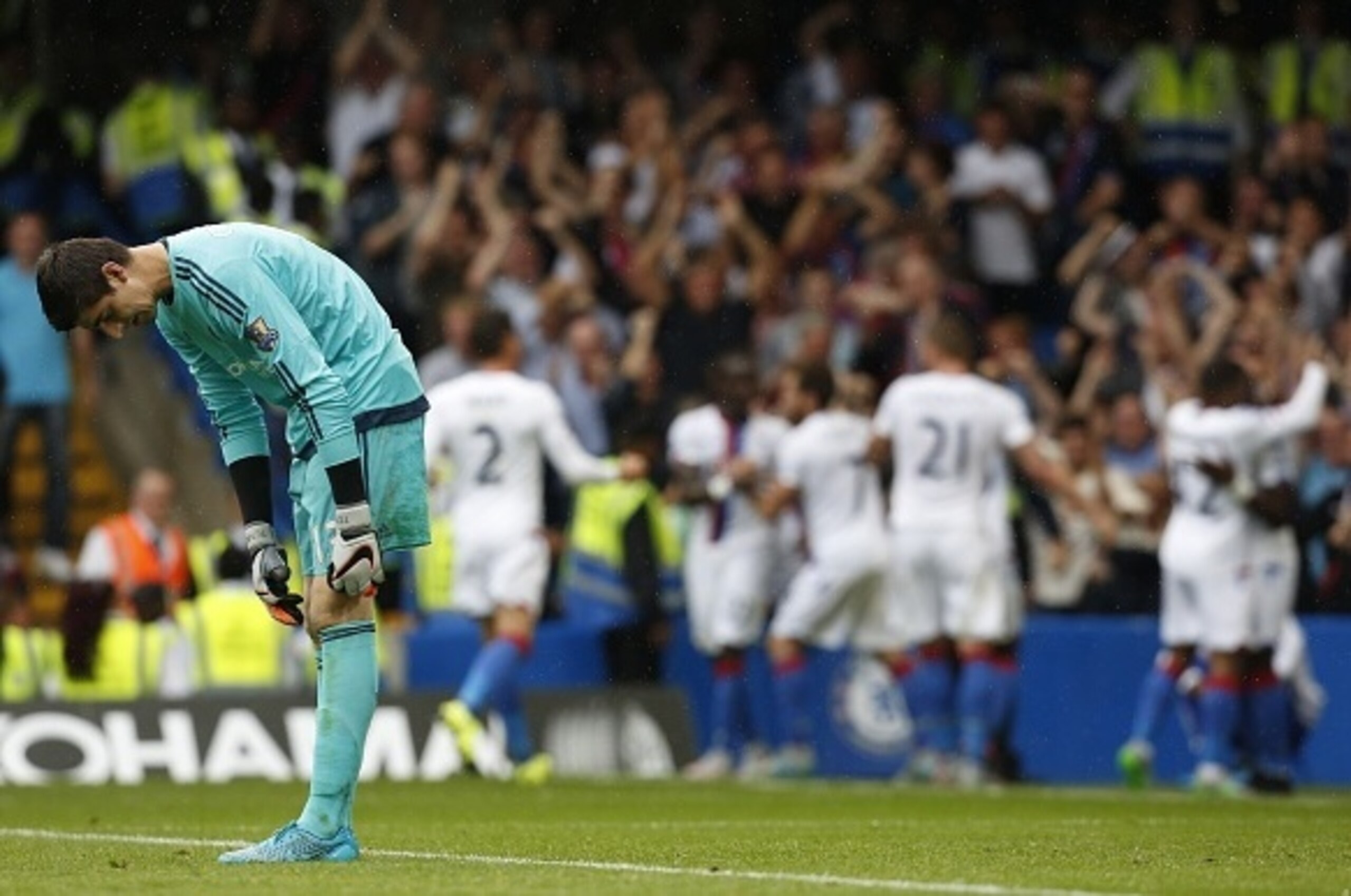 Chelseas Belgian goalkeeper Thibaut Courtois reacts as the Crystal Palace team celebrate Crystal Palaces first goal during the English Premier League football match between Chelsea and Crystal Palace at Stamford Bridge in London on August 29, 2015. Crysta