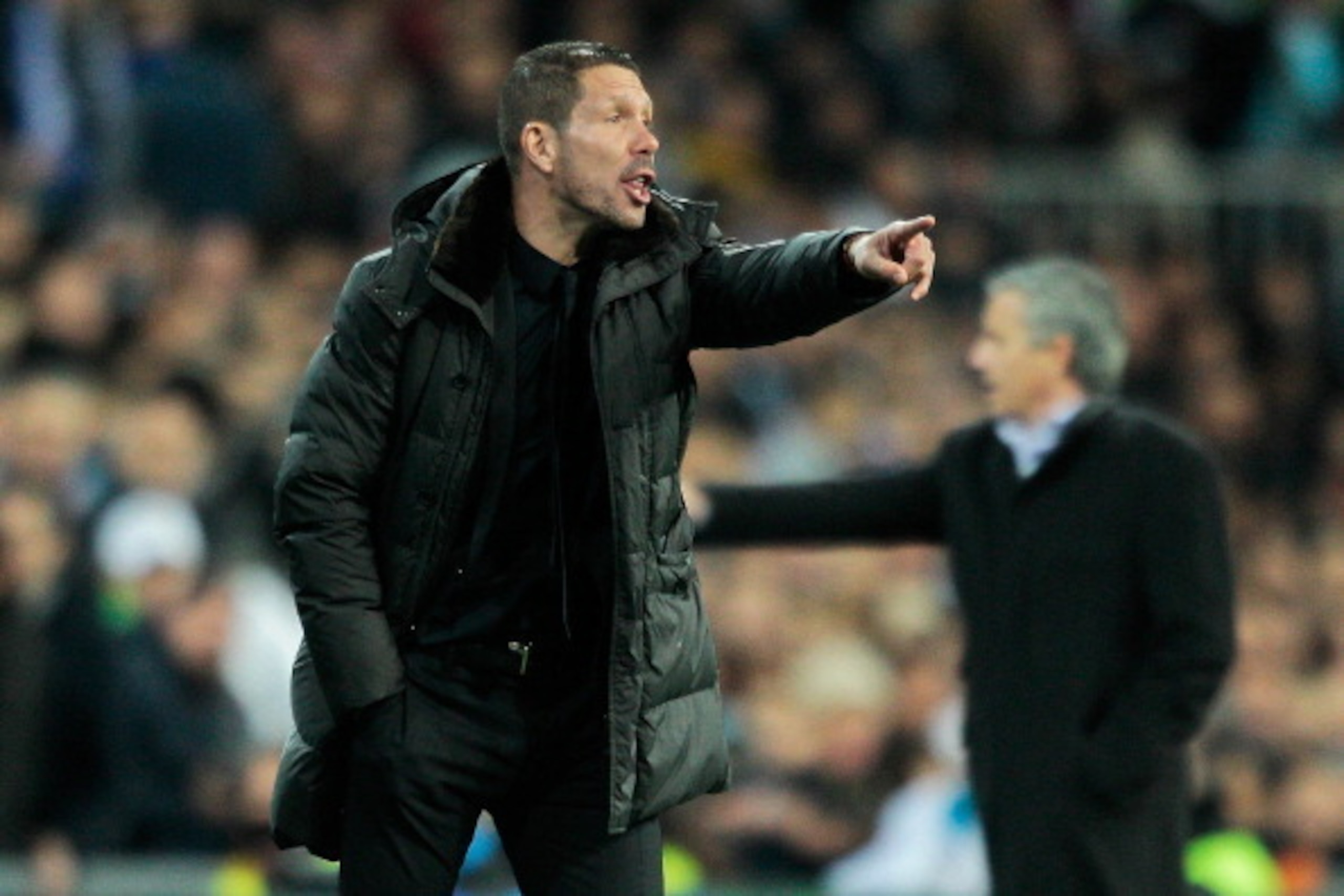 MADRID, SPAIN - DECEMBER 01: Head coach Diego Simeone of Club Atletico de Madrid gives instructions behind him head coach Jose Mourinho of Real Madrid CF during the La Liga match between Real Madrid CF and Club Atletico de Madrid at Estadio Santiago Berna
