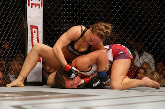 LAS VEGAS, NV - DECEMBER 28:  Ronda Rousey (top) punches Miesha Tate in their UFC women's bantamweight championship bout during the UFC 168 event at the MGM Grand Garden Arena on December 28, 2013 in Las Vegas, Nevada. (Photo by Josh Hedges/Zuffa LLC/Zuff