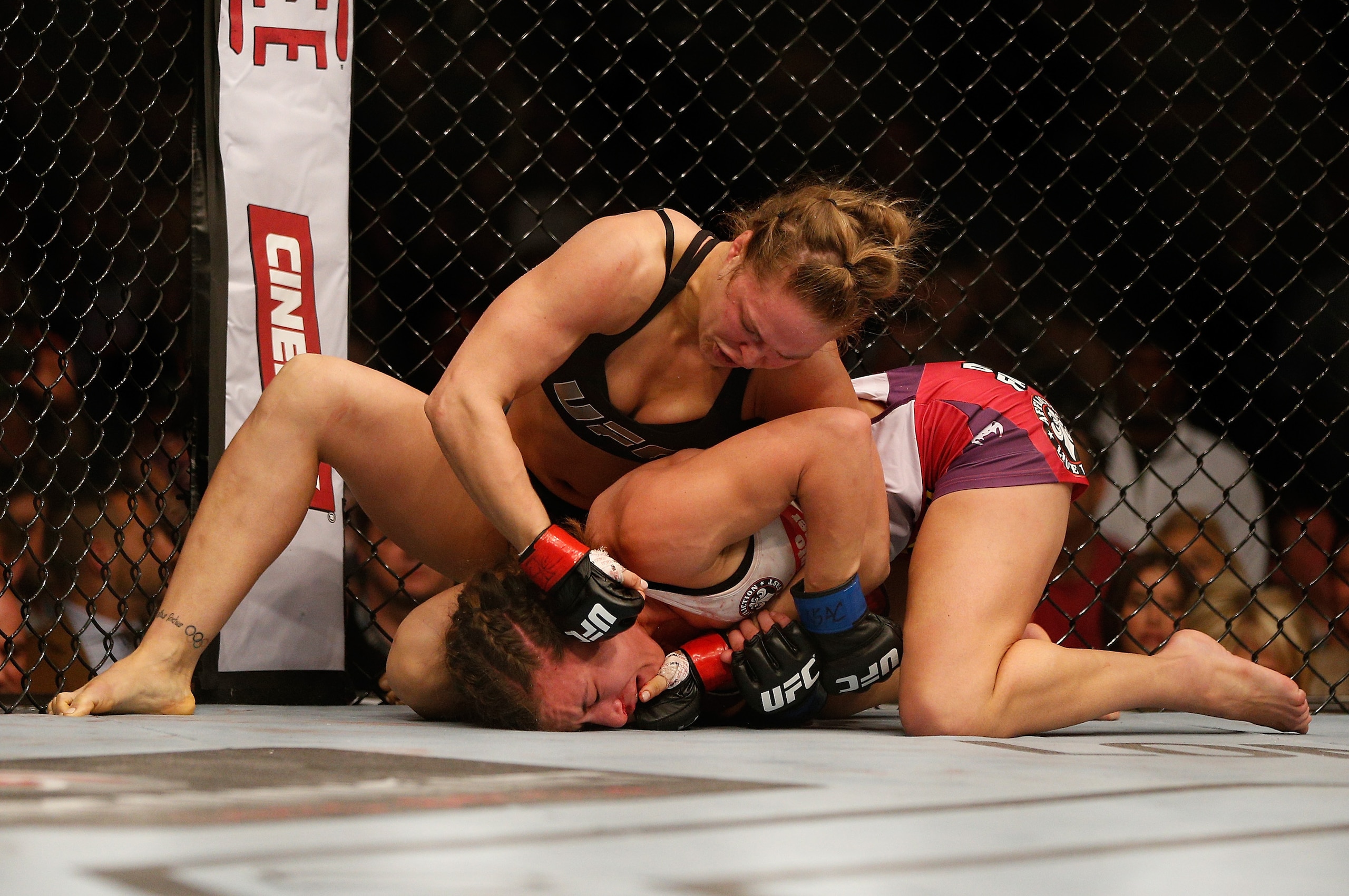LAS VEGAS, NV - DECEMBER 28:  Ronda Rousey (top) punches Miesha Tate in their UFC women's bantamweight championship bout during the UFC 168 event at the MGM Grand Garden Arena on December 28, 2013 in Las Vegas, Nevada. (Photo by Josh Hedges/Zuffa LLC/Zuff
