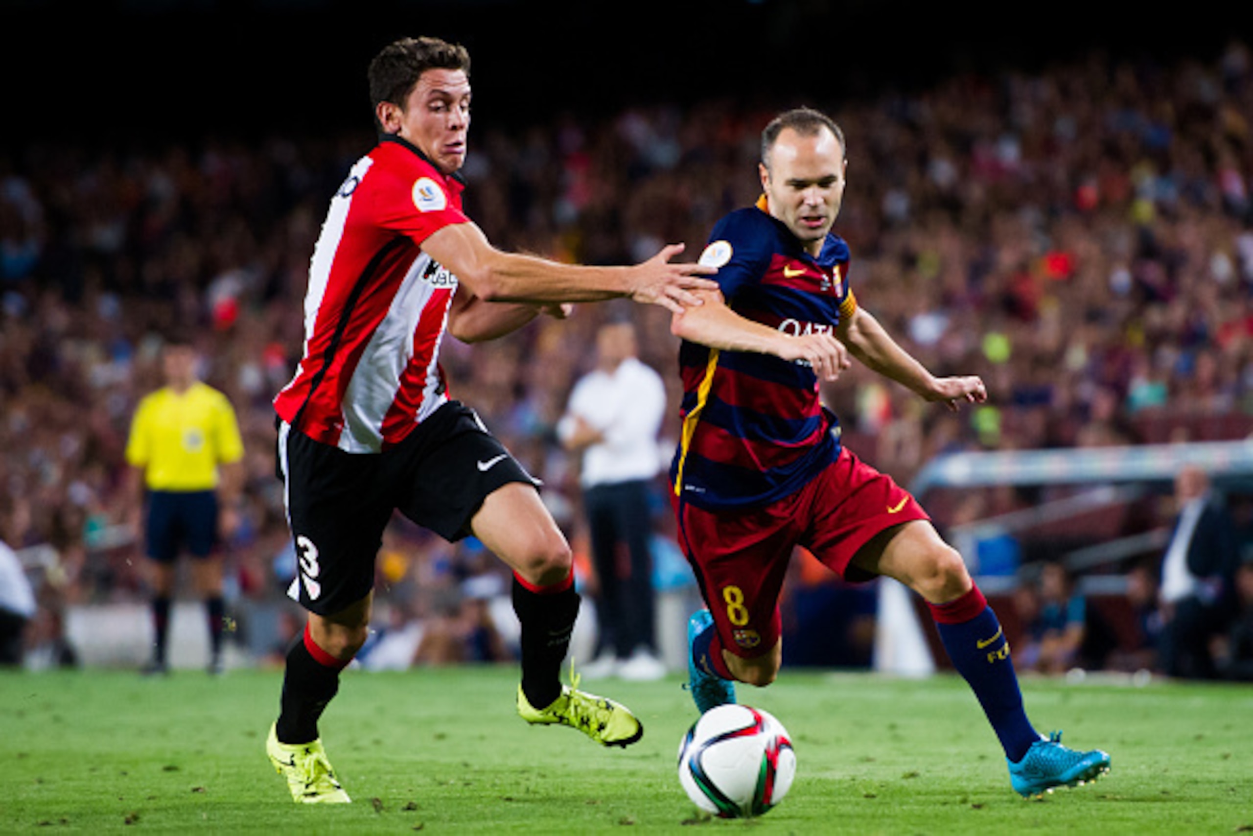 BARCELONA, SPAIN - AUGUST 17:  Andres Iniesta (R) of FC Barcelona runs past Gorka Elustondo of Athletic Club during the Spanish Super Cup second leg match between FC Barcelona and Athletic Club at Camp Nou on August 17, 2015 in Barcelona, Spain.  (Photo b
