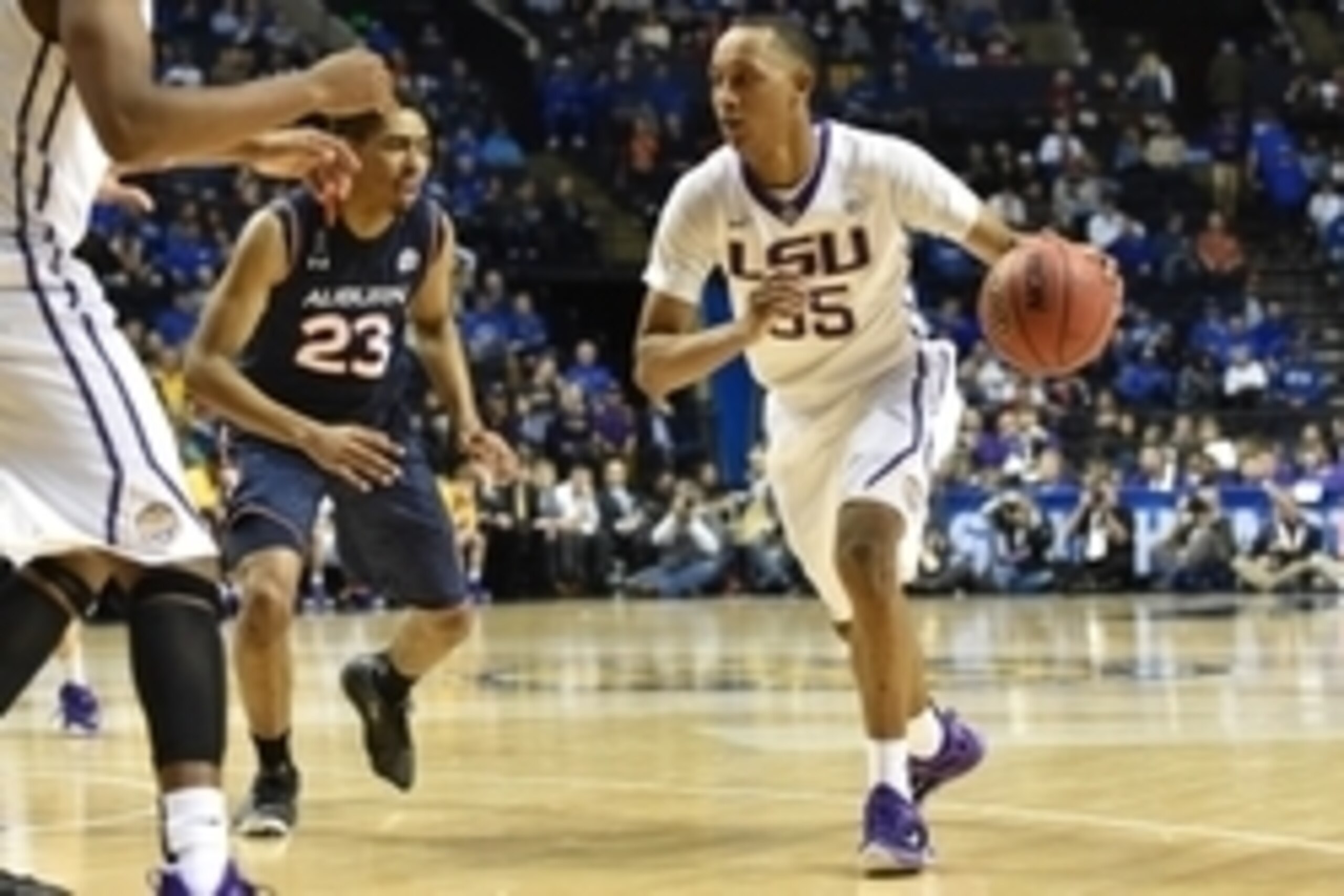Mar 13, 2015; Nashville, TN, USA; LSU Tigers guard Tim Quarterman (55) keeps the ball away from Auburn Tigers guard TJ Lang (23) during the third round of the SEC Conference Tournament at Bridgestone Arena. Mandatory Credit: Don McPeak-USA TODAY Sports