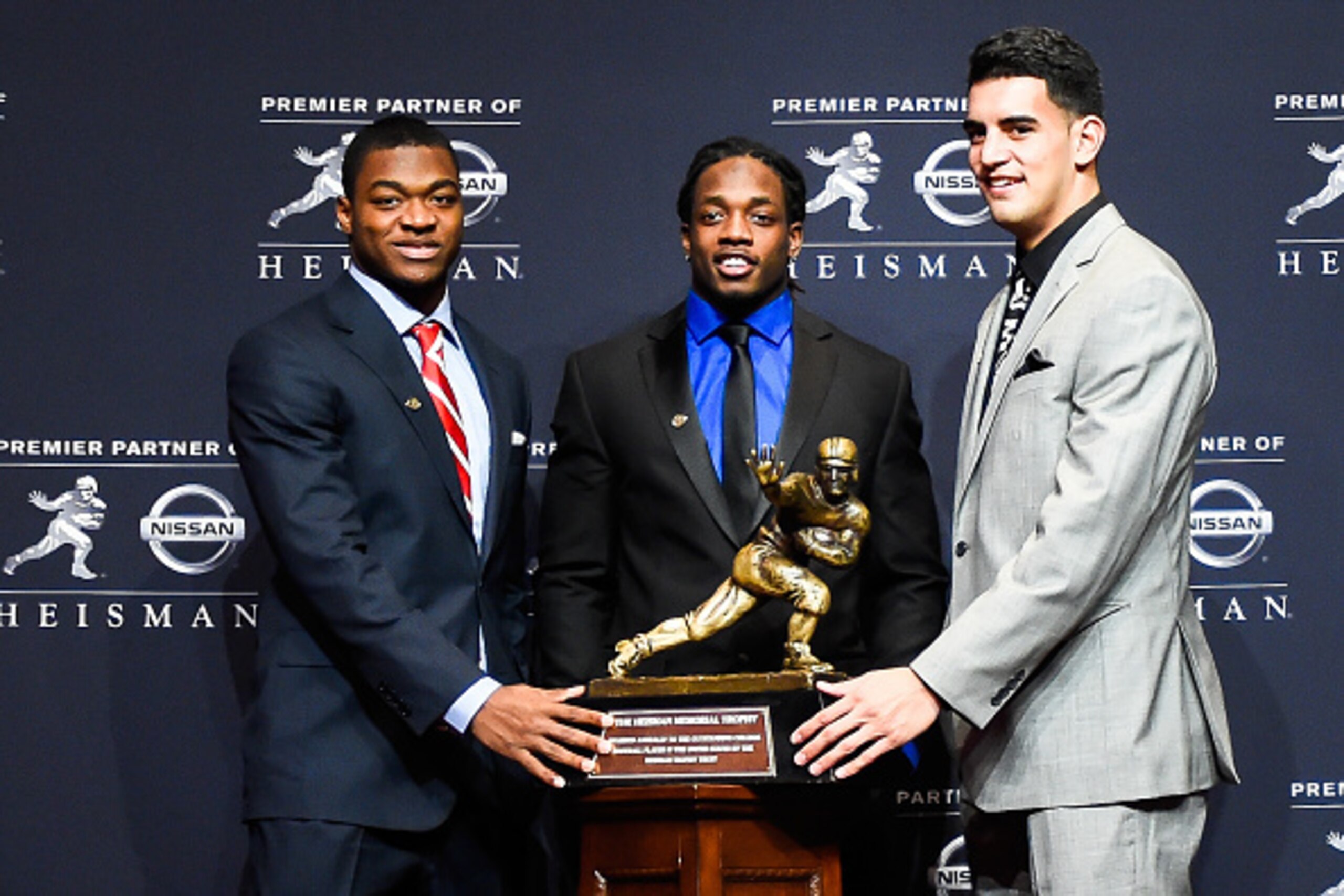 NEW YORK, NY - DECEMBER 13:  (L-R) Amari Cooper, Melvin Gordon, and Marcus Mariota pose for a picture with the Heisman Trophy during a press conference at the New York Marriott Marquis on December 13, 2014 in New York City.  (Photo by Alex Goodlett/Getty 