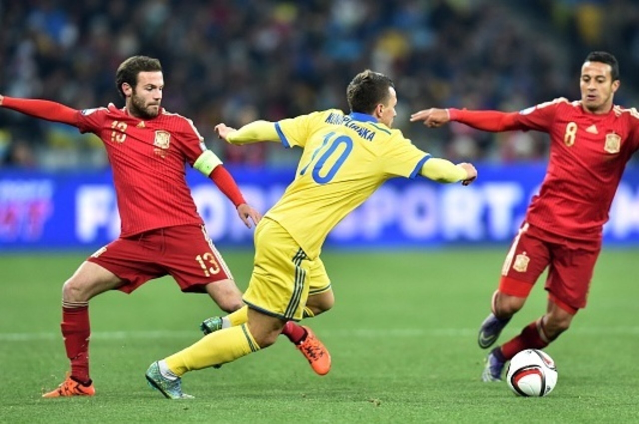 Ukraine's midfielder Yevhen Konoplianka (C) vies with Spain's midfielder Juan Mata (L) during the Euro 2016 qualifying football match between Ukraine and Spain at Olympiysky stadium in Kiev on October 12, 2015.  AFP PHOTO /  GENYA  SAVILOV        (Photo c