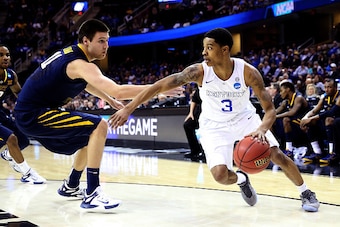 CLEVELAND, OH - MARCH 26: Tyler Ulis #3 of the Kentucky Wildcats handles the ball against Nathan Adrian #11 of the West Virginia Mountaineers in the second half during the Midwest Regional semifinal of the 2015 NCAA Men's Basketball Tournament at Quicken