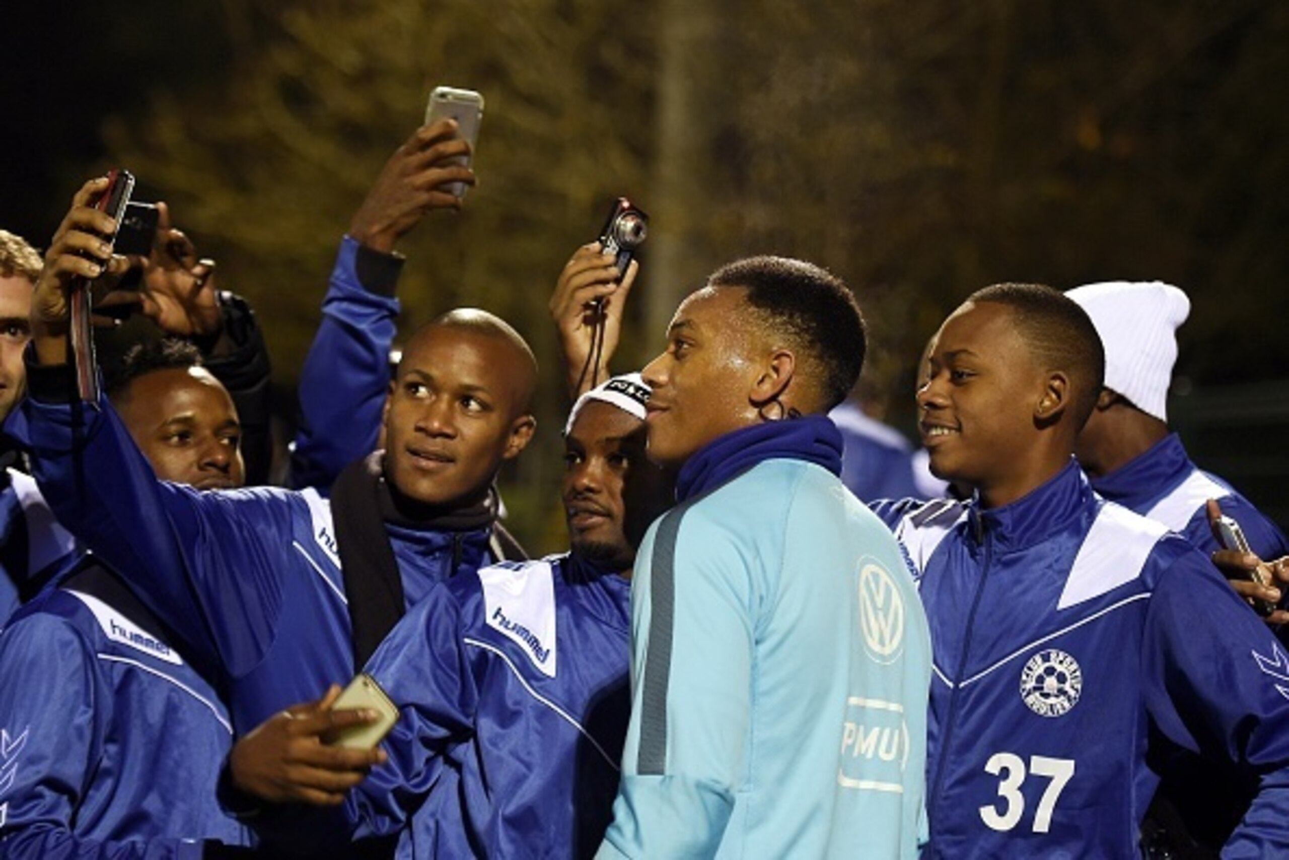 France's forward Anthony Martial (C) poses for a selfie with fans during a training session in Clairefontaine-en-Yvelines on November 10, 2015 ahead of a friendly football match between France and Germany to be held on November 13. AFP PHOTO / FRANCK FIFE