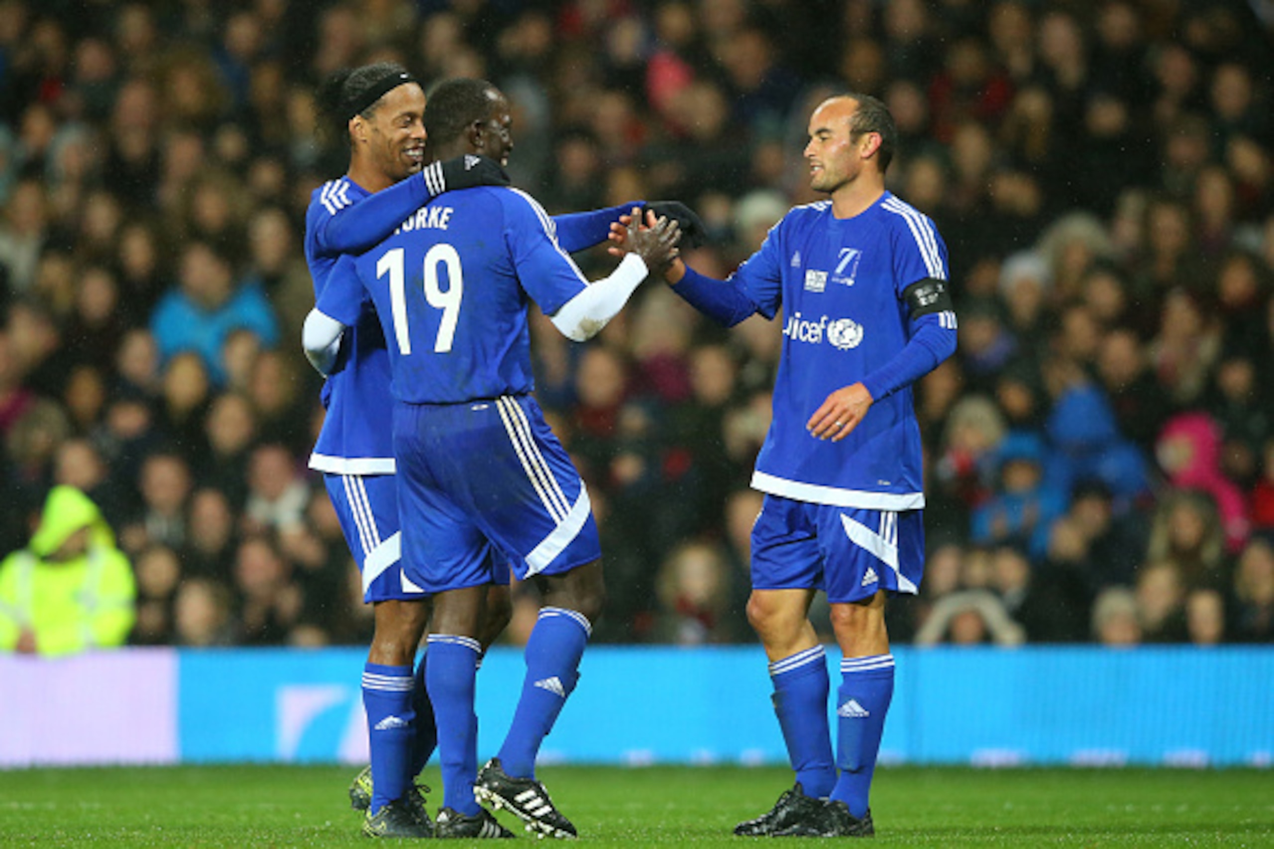 MANCHESTER, ENGLAND - NOVEMBER 14: Dwight Yorke #19 of the Rest of the World celebrates with teammates Ronaldinho Gaucho (L) and Landon Donovan after scoring a goal during the David Beckham Match for Children in aid of UNICEF between Great Britain & Irel MANCHESTER, ENGLAND - NOVEMBER 14: Dwight Yorke #19 of the Rest of the World celebrates with teammates Ronaldinho Gaucho (L) and Landon Donovan after scoring a goal during the David Beckham Match for Children in aid of UNICEF between Great Britain & Irel