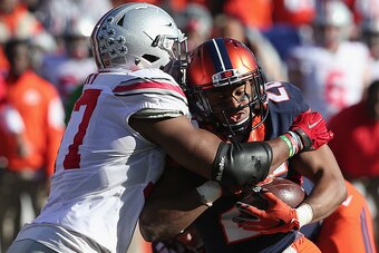 CHAMPAIGN, IL - NOVEMBER 14:  Cameron Tucker #26 of the Illinois Fighting Illini is tackled for a loss by Joshua Perry #37 of the Ohio State Buckeyes at Memorial Stadium on November 14, 2015 in Champaign, Illinois.  (Photo by Jonathan Daniel/Getty Images)
